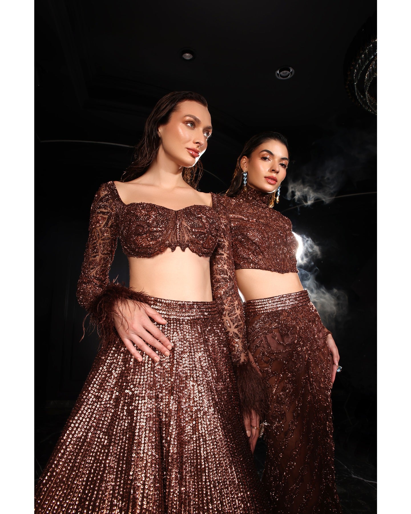 Embrace the allure of the Orave lehenga with its choli cut blouse adorned in Swarovski crystals, feathers, and sequins, complemented by a captivating feather cape.