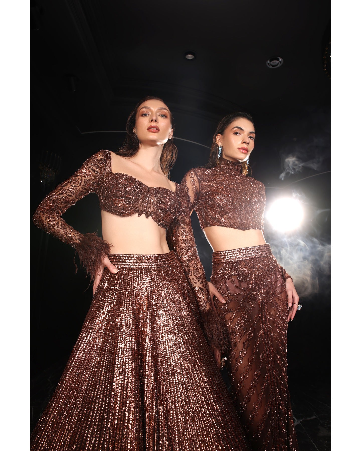 Embrace the allure of the Orave lehenga with its choli cut blouse adorned in Swarovski crystals, feathers, and sequins, complemented by a captivating feather cape.