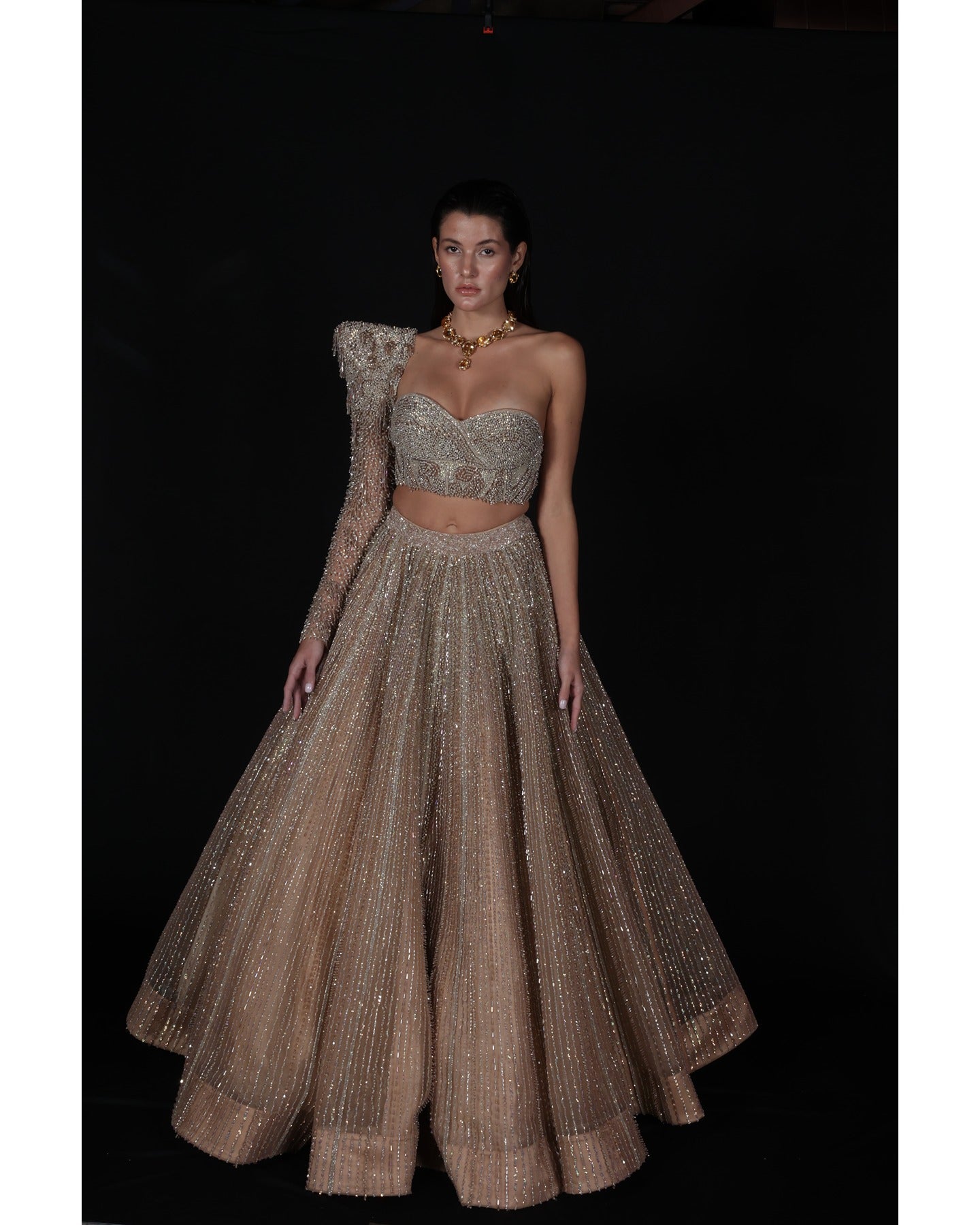 Elevate your elegance in our Champagne Lehenga, a sparkling symphony of stones, crystals, sequins, and Japanese cut-dana.
