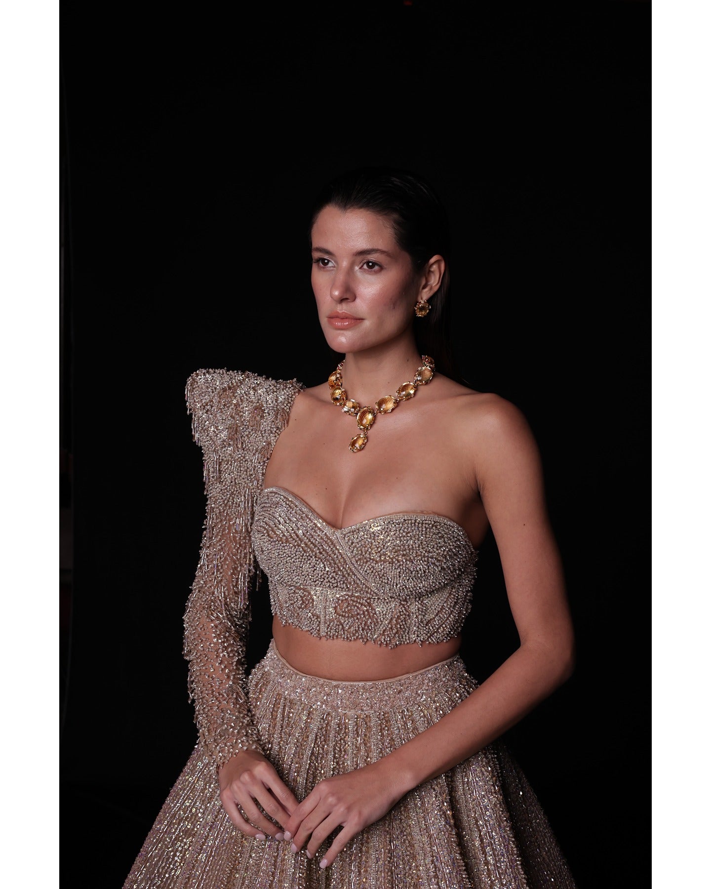 Elevate your elegance in our Champagne Lehenga, a sparkling symphony of stones, crystals, sequins, and Japanese cut-dana.
