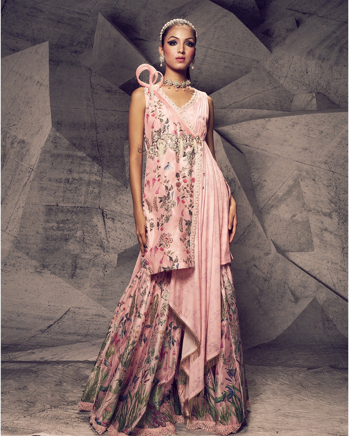 Bathed in the enchanting hues of pink, this sharara ensemble is adorned with delicate pearl embroidery, creating a look that is both graceful and timeless.