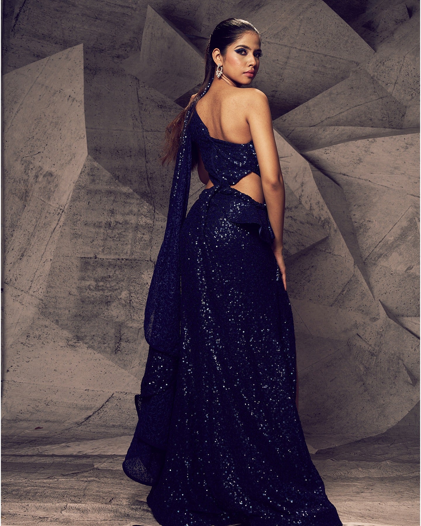 Draped in the bold allure of blue, this slit gown is a striking masterpiece, adorned with intricate floral embroidery, stones, sequins, and kardana beads, making each step a statement of elegance and glamour.