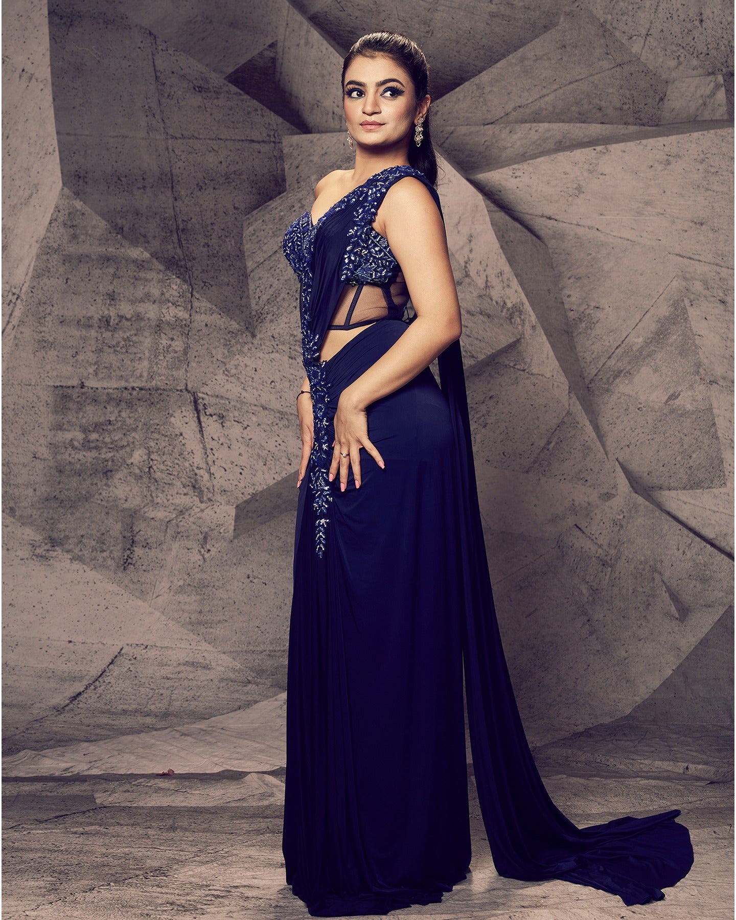Draped in the timeless allure of blue, this off-shoulder saree ensemble is a fusion of classic charm and contemporary style, creating a captivating silhouette that turns every occasion into a runway moment. 