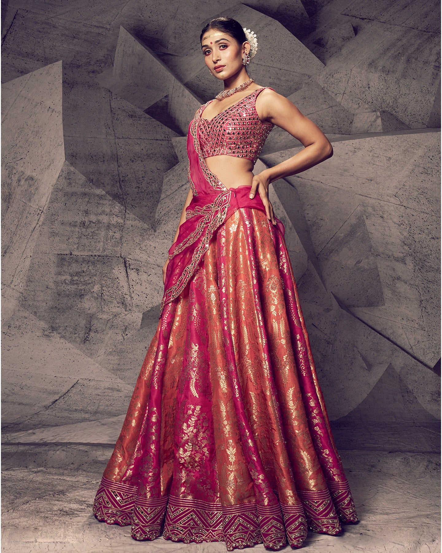 Drenched in the royal hues of rani pink, this lehenga is a symphony of opulent details.