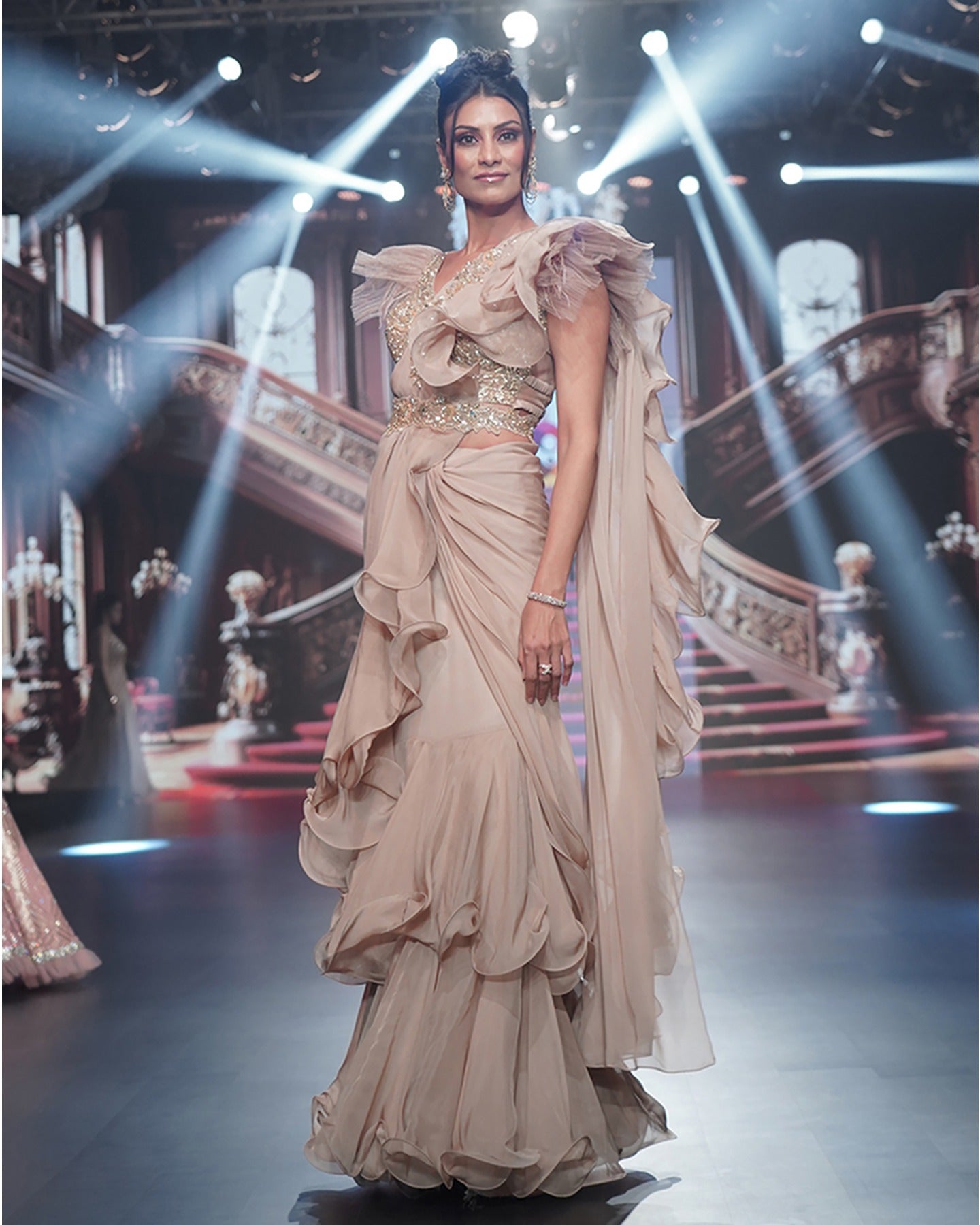 Draped in the timeless allure of beige, this saree is a canvas of earthy elegance and shimmering floral gold embroidery.