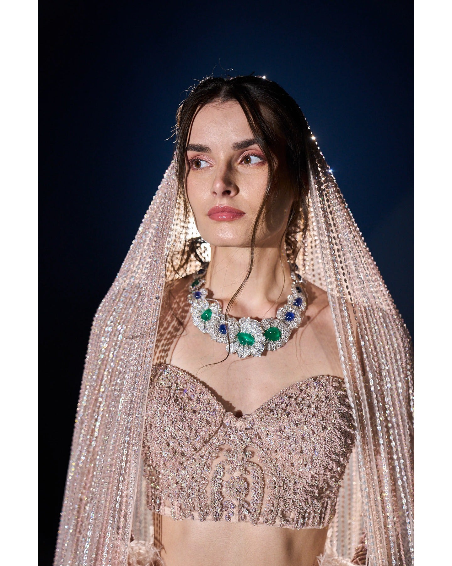 Draped in elegance, our Nude Pink Lehenga intricately embellished with stones, crystals, sequins, and Japanese cut-dana, unveils a timeless symphony of grace and sophistication.