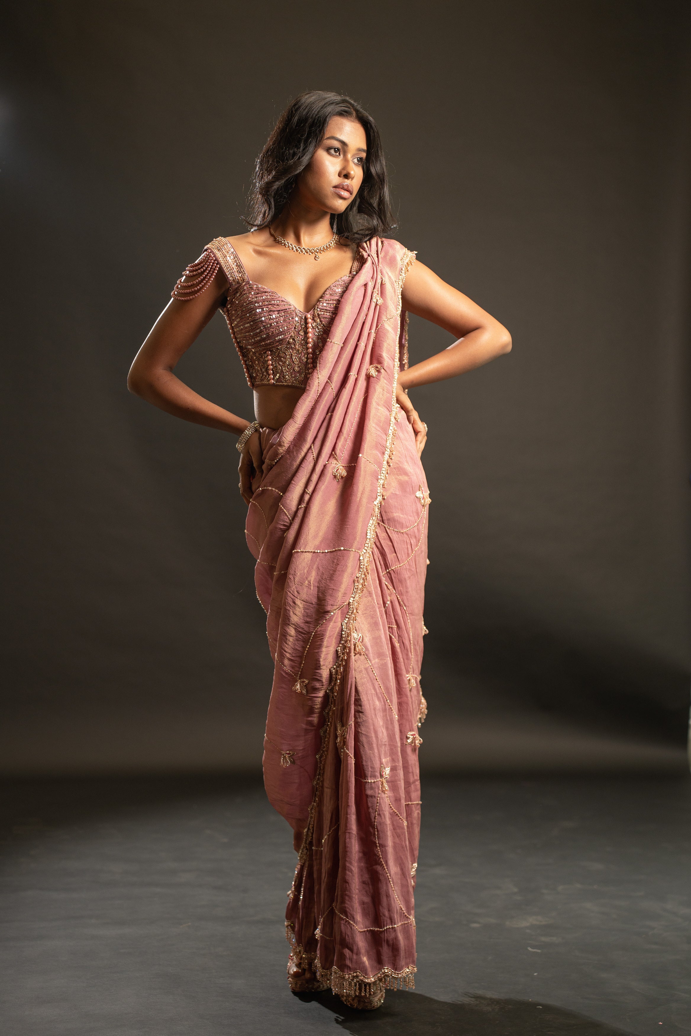 Enchanting in every detail: This dusty rose saree, adorned with shimmer tissue, velvet, and net, is a testament to luxurious style.