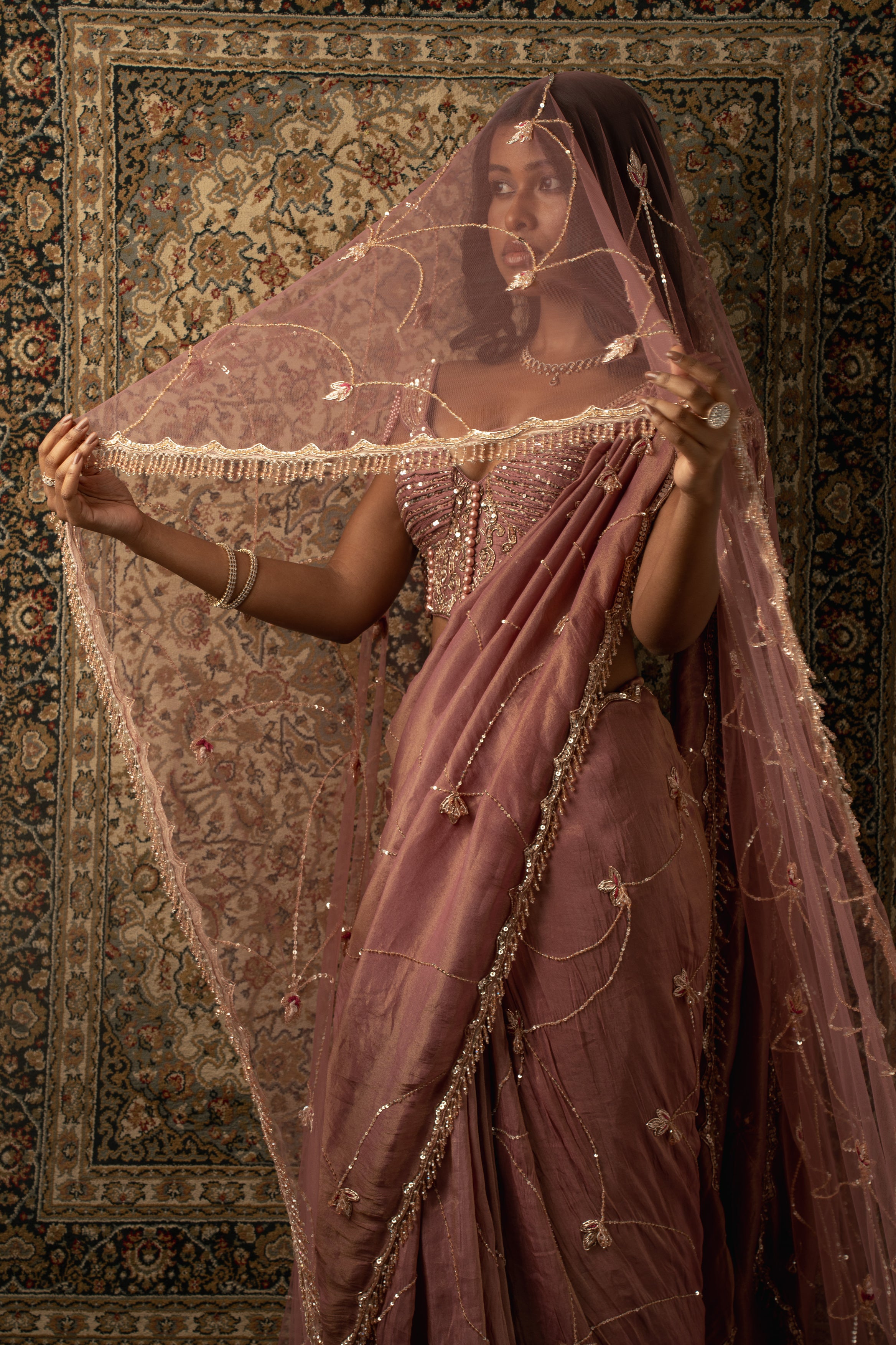 Draped in opulence: Dusty rose shimmer tissue saree, velvet blouse, and net petticoat come together to create a vision of sheer beauty.