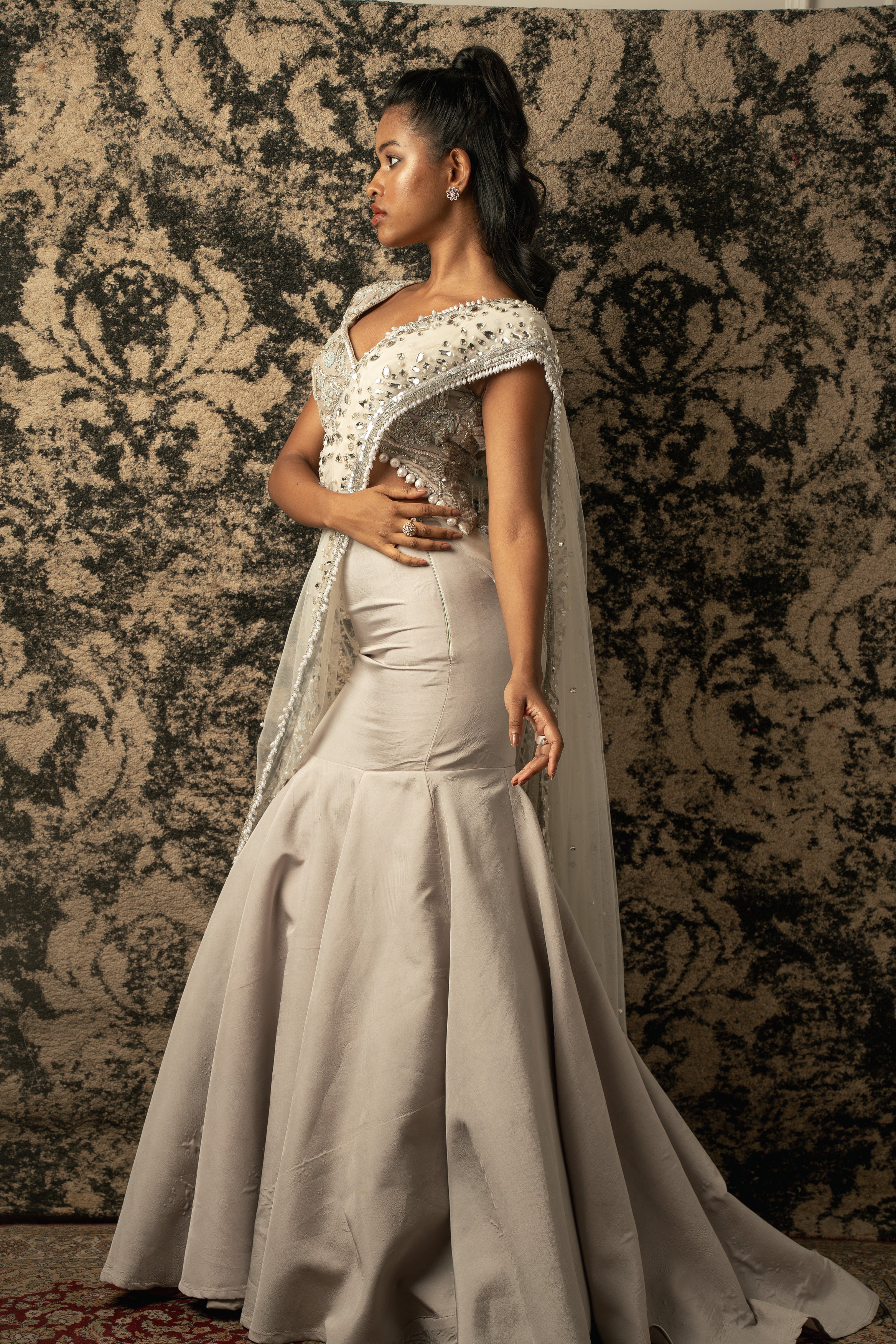 Elegance personified: Chalk Net Drape Saree with a luxurious Velvet blouse and Habutai Silk skirt, a regal ensemble that commands attention.