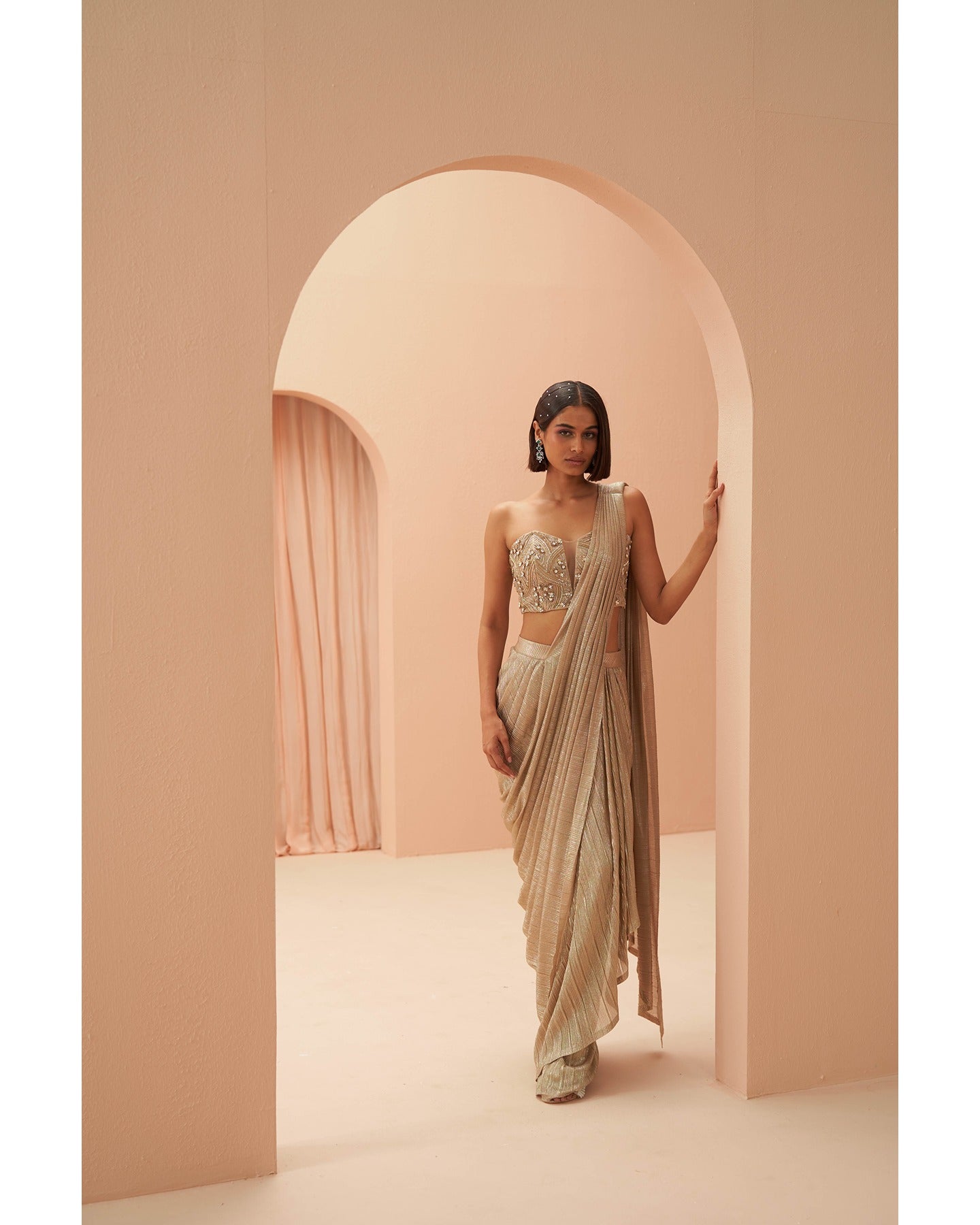 Gilded Grace: Hand-embroidered enchantment graces this golden drape saree, a radiant masterpiece of timeless elegance.