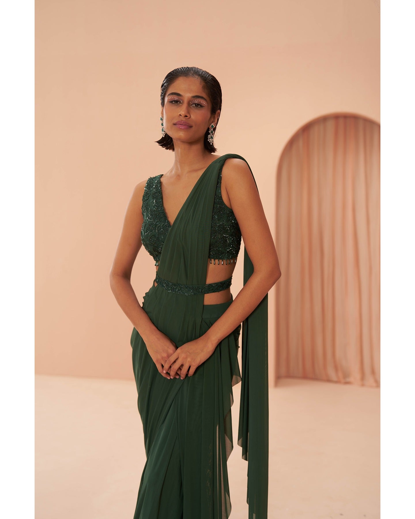 Bottled Beauty: Hand-embroidered elegance adorns this bottle green drape saree, a captivating symphony of sophistication.