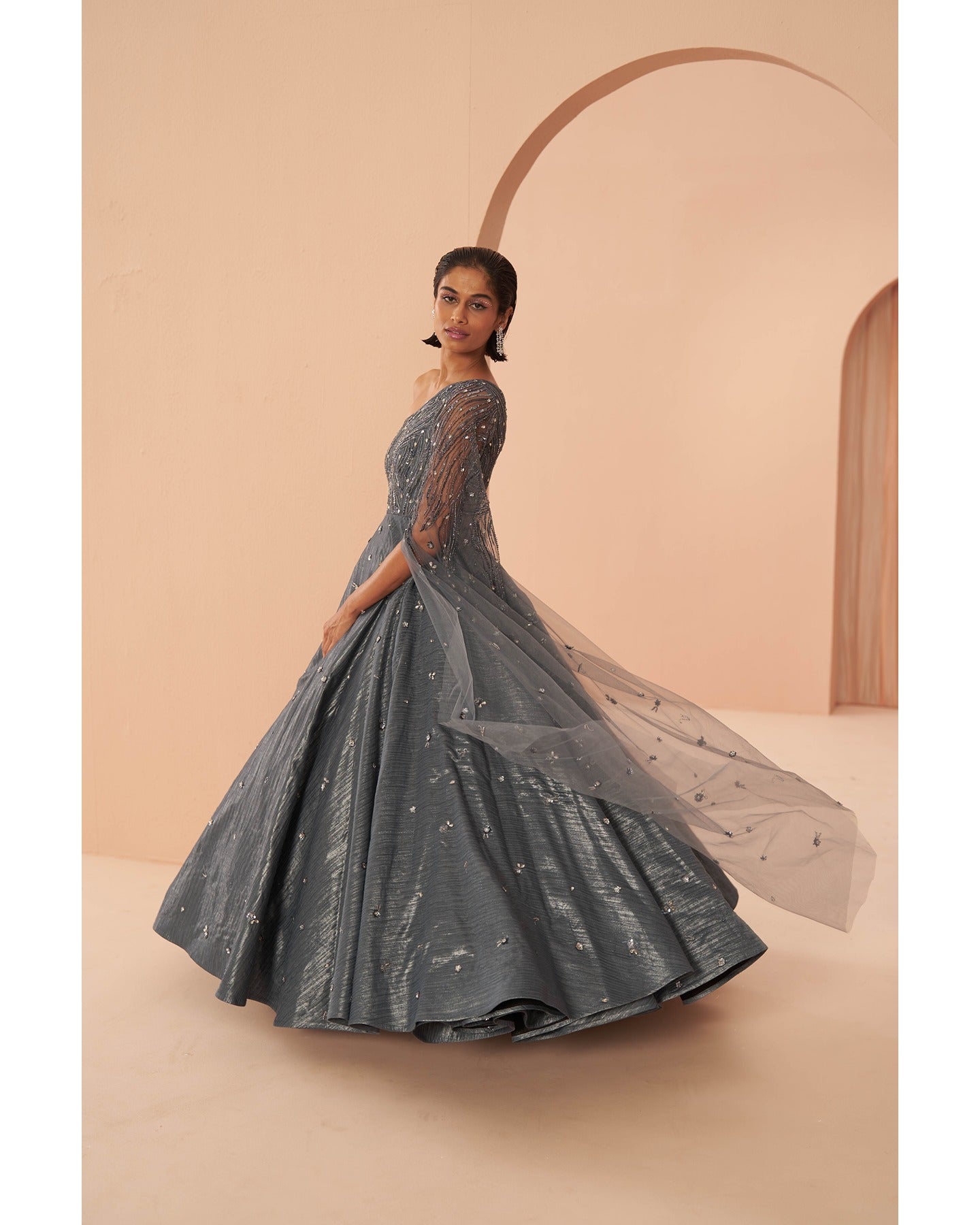 Sapphire Splendor: Hand-embroidered grace adorns this one-shoulder gown in a captivating shade of blue.