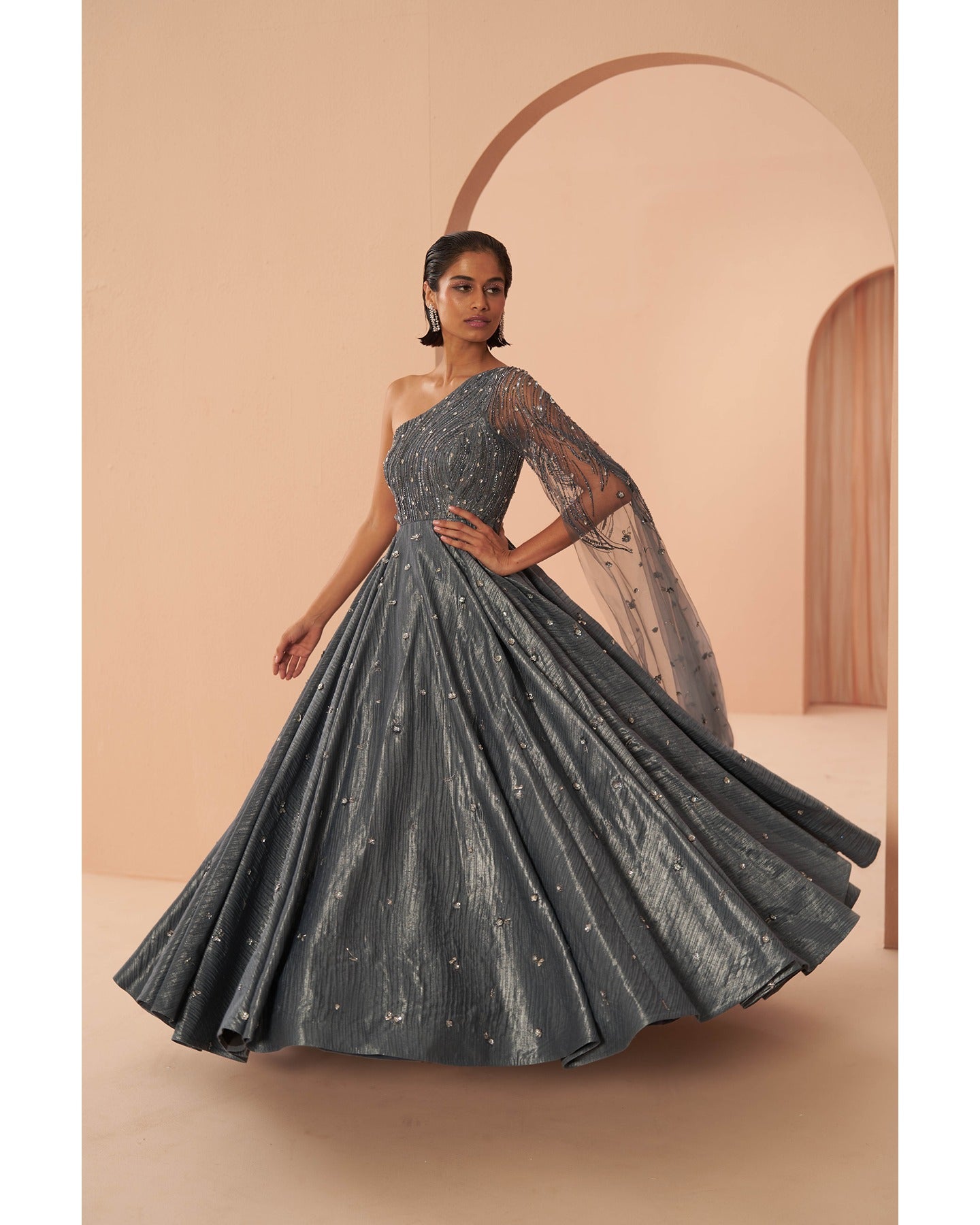 Sapphire Splendor: Hand-embroidered grace adorns this one-shoulder gown in a captivating shade of blue.