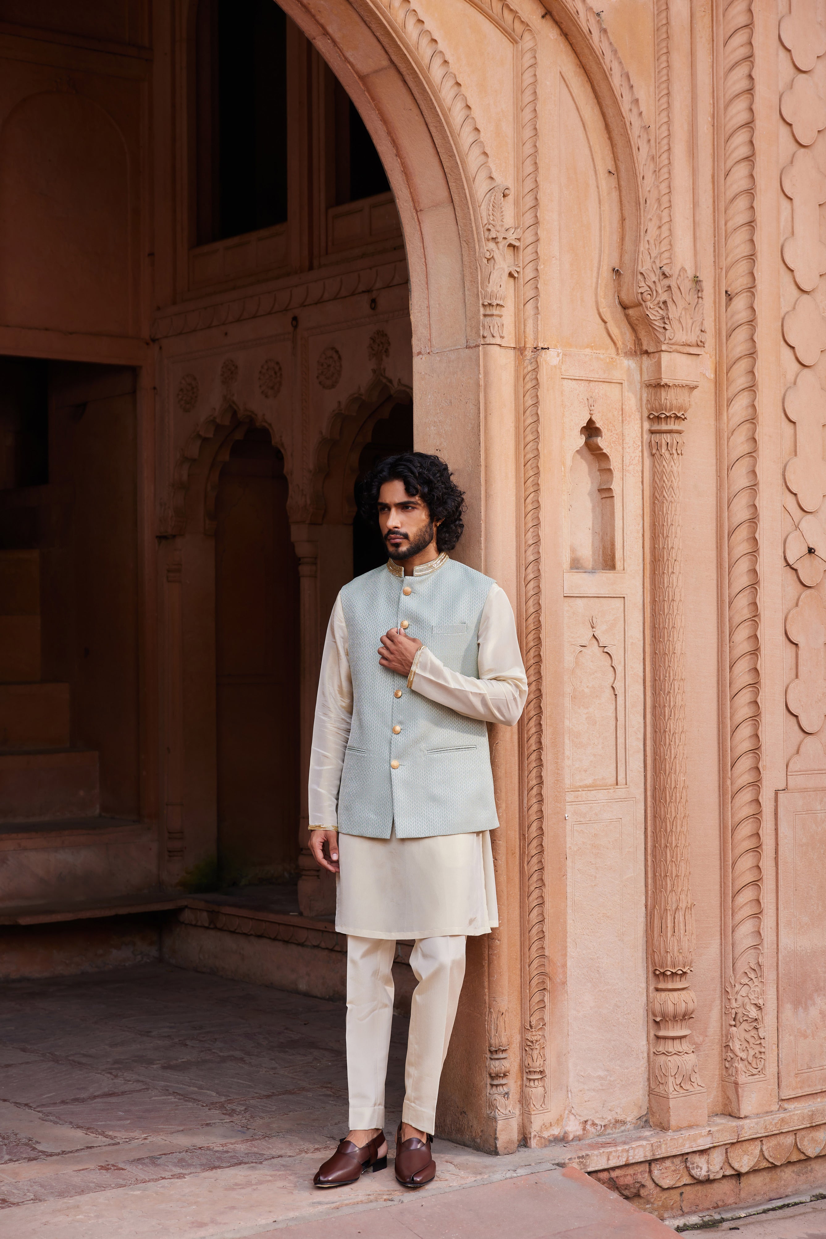 A Nehru jacket with an embroidered collar, paired with a beige kurta and pants