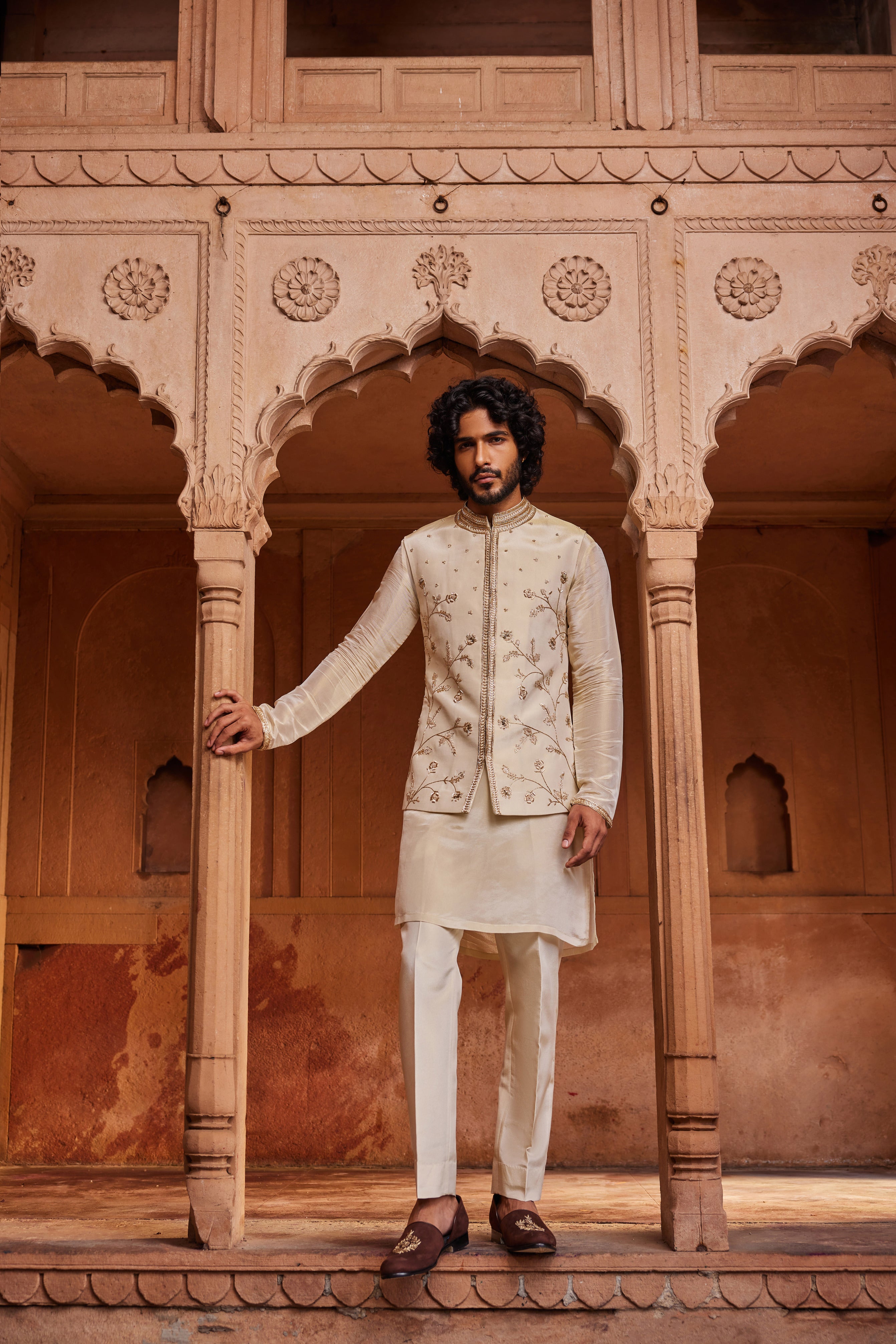 A Nehru jacket with intricate floral zardozi, dabka, and zari handwork, paired with a monotone detailed kurta and pants.