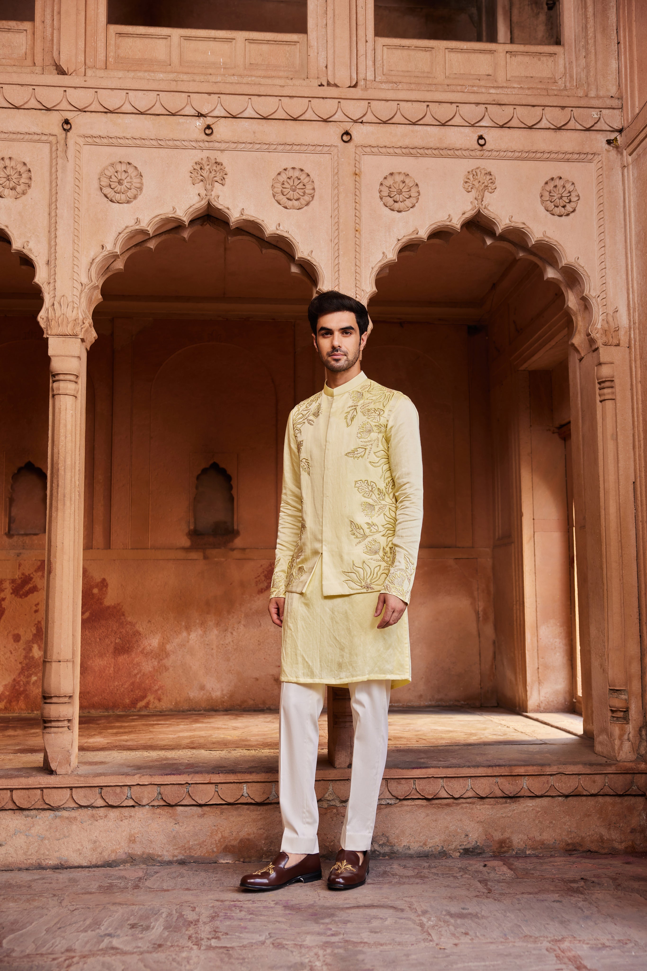 A Nehru jacket embroidered with tonal resham, zardozi, and glass beads in floral motifs, paired with a kurta featuring detailed embroidery on the sleeves and matching pants.