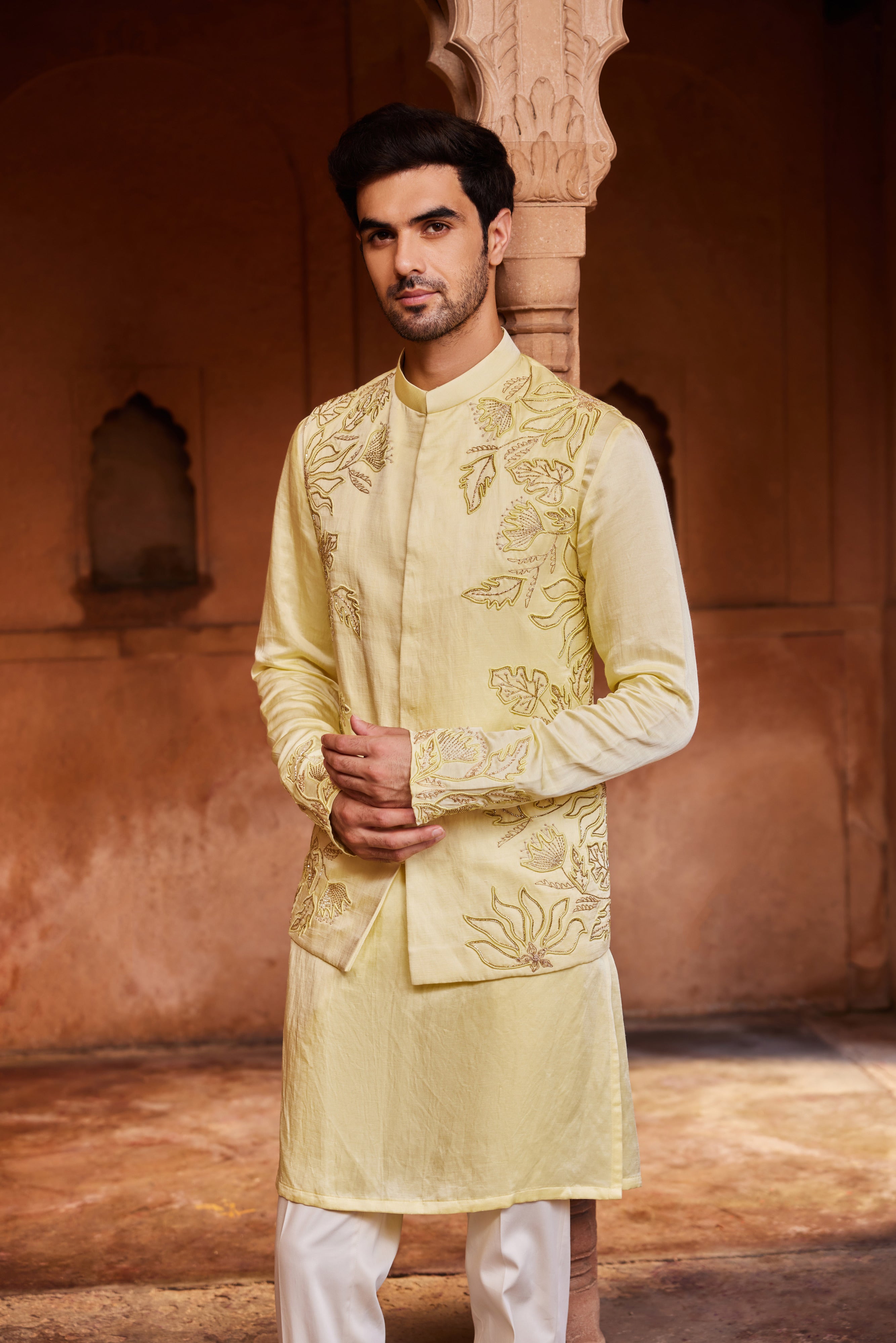 A Nehru jacket adorned with tonal resham, zardozi, and glass beads, forming intricate floral motifs. The kurta sleeves are embellished with detailed embroidery, and the set is completed with matching pants for a refined look.