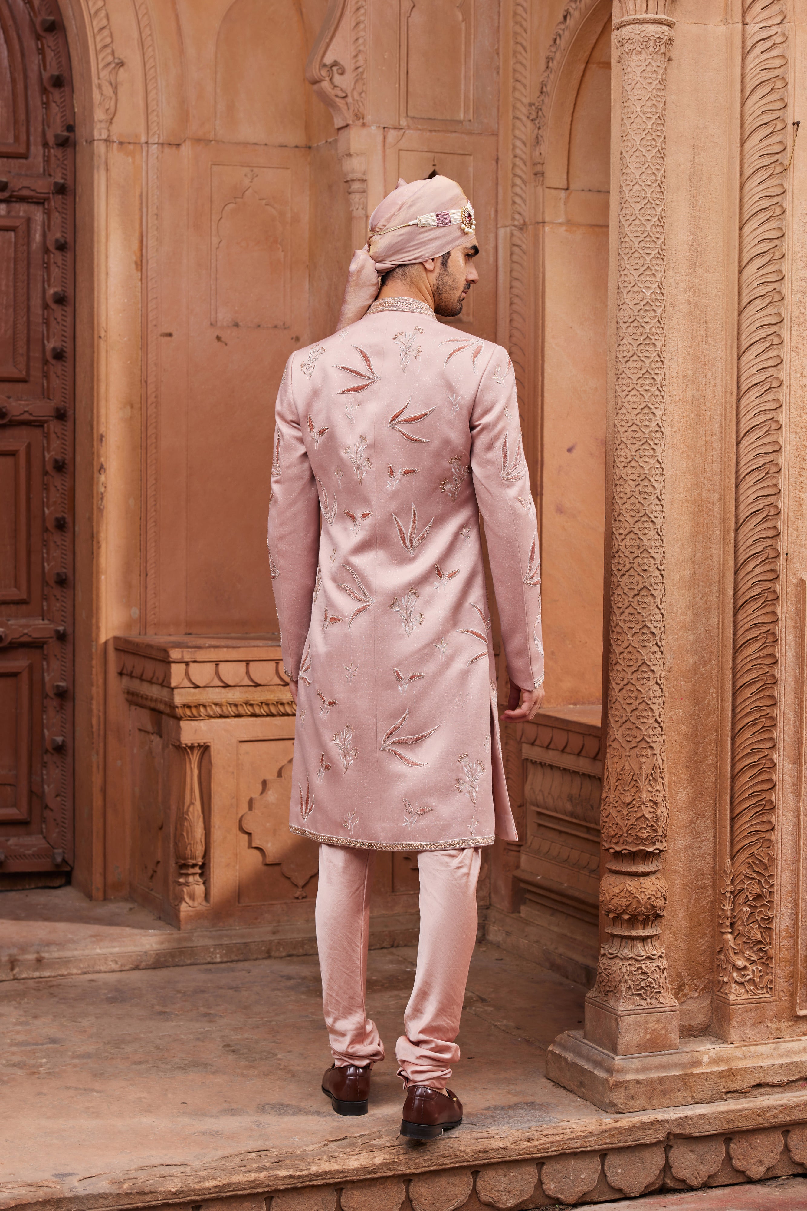 Full view of a sherwani adorned with tonal velvet applique and floral butta embroidery in zari and dabka, paired with a kurta, pants, and an elegant embroidered stole.