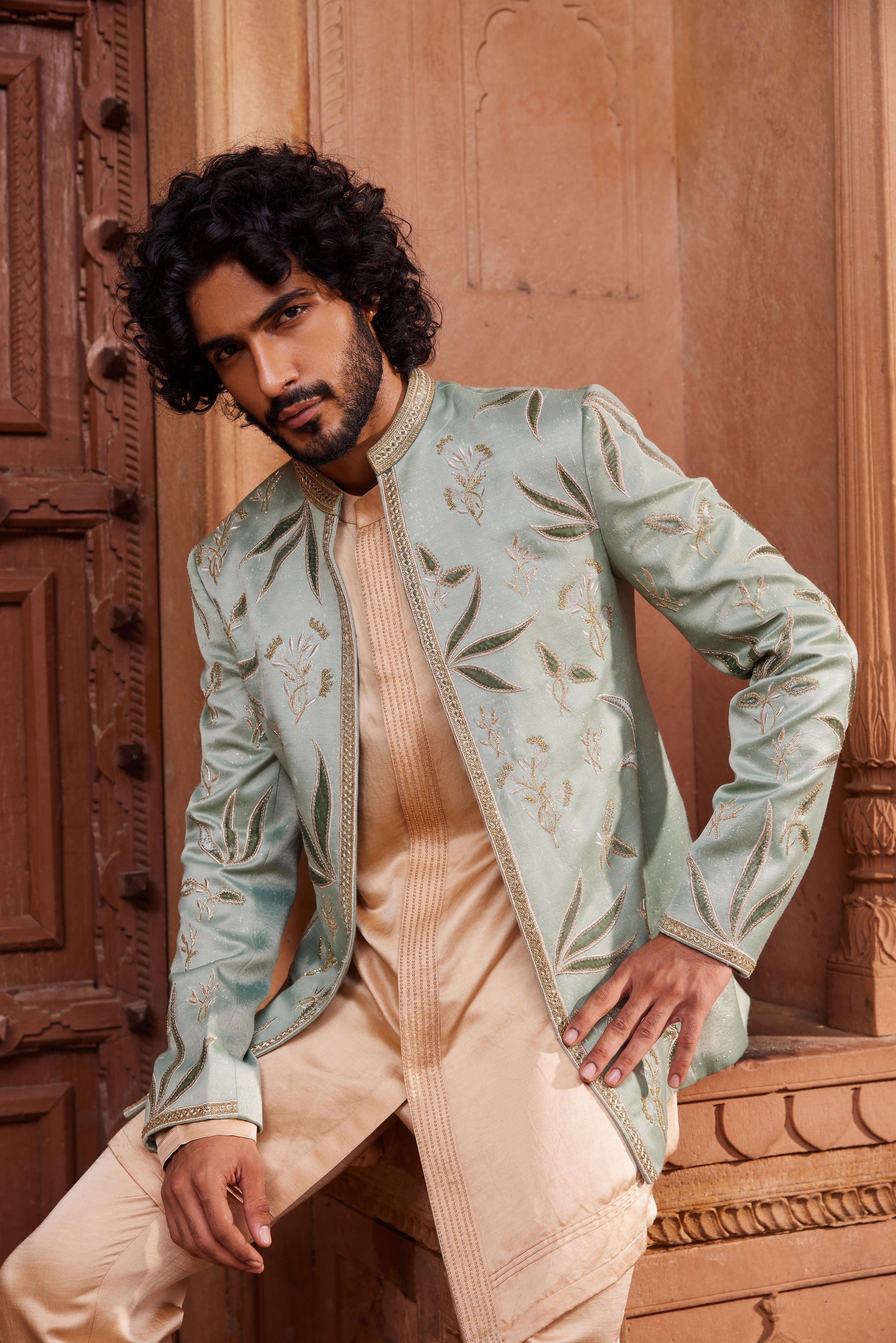 Full view of a royal jacket set, showcasing rich velvet applique with dabka, zari, and cutdana embellishments, paired with a front-open detailed kurta and pants for an elegant ensemble.
