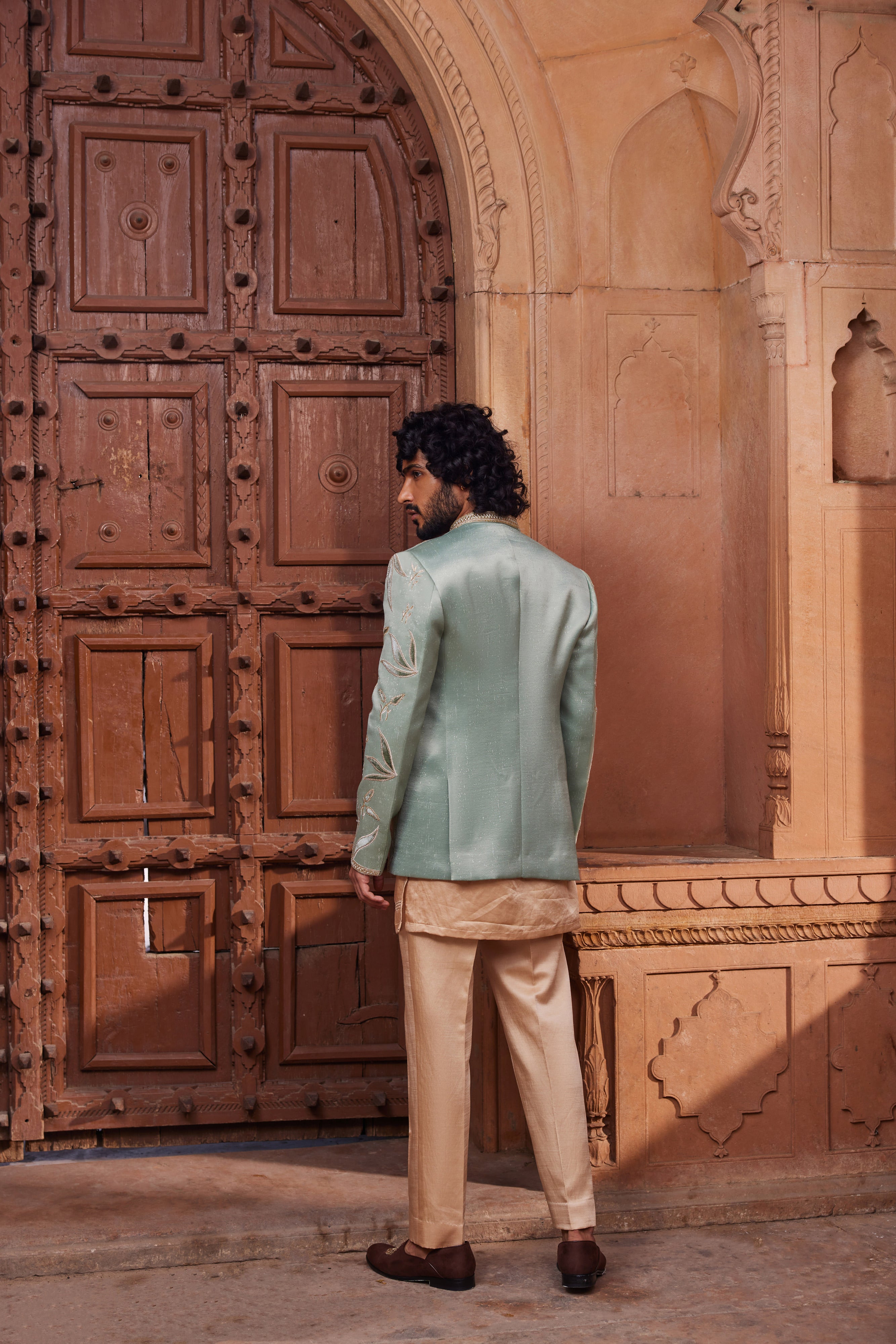 Full view of a royal jacket set, showcasing rich velvet applique with dabka, zari, and cutdana embellishments, paired with a front-open detailed kurta and pants for an elegant ensemble.