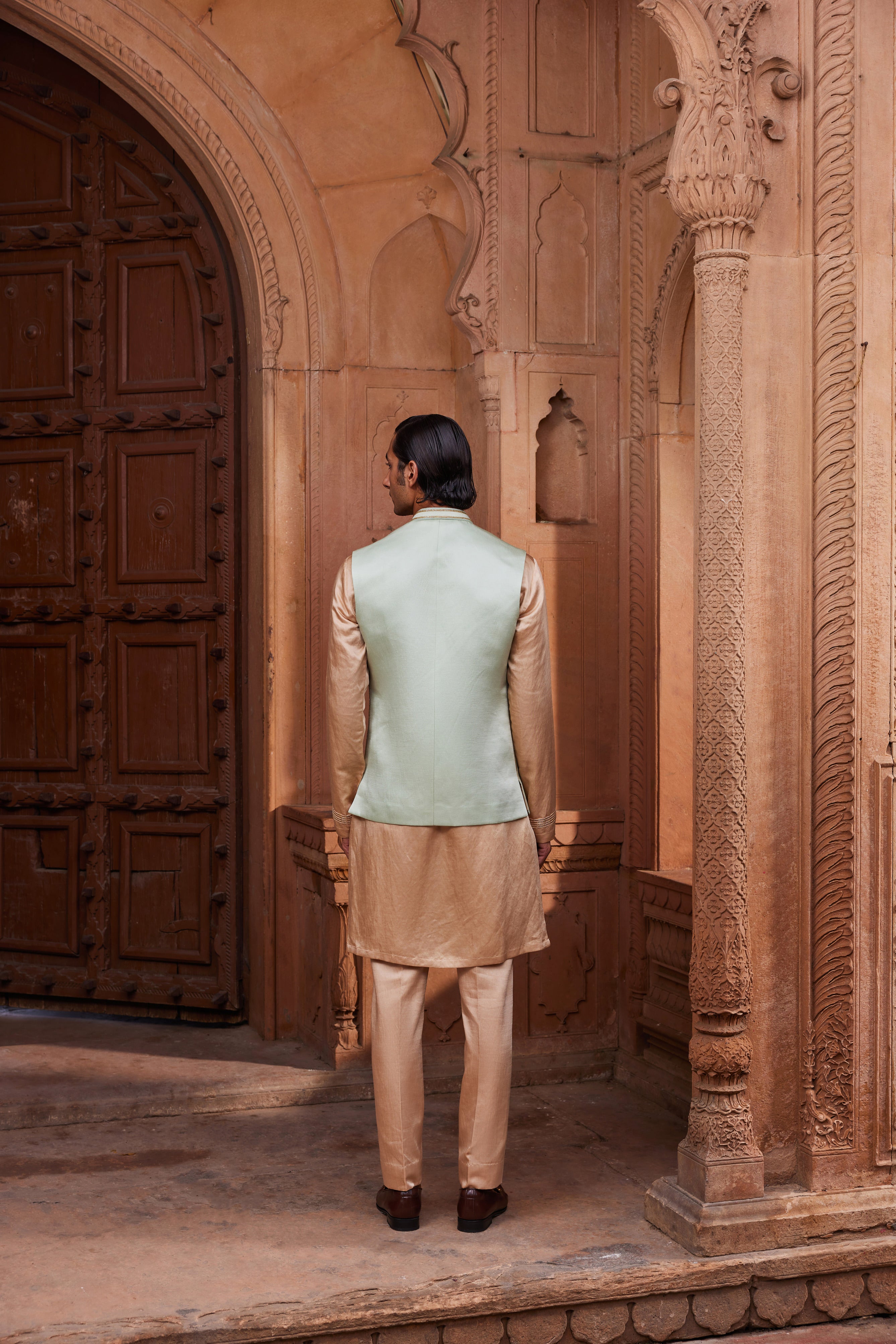 A Nehru jacket adorned with delicate gold and tonal kiran dori hand embellishments, paired with a contrasting beige kurta and pants for a refined and elegant ensemble.
Alt Text (Descriptive): A Nehr