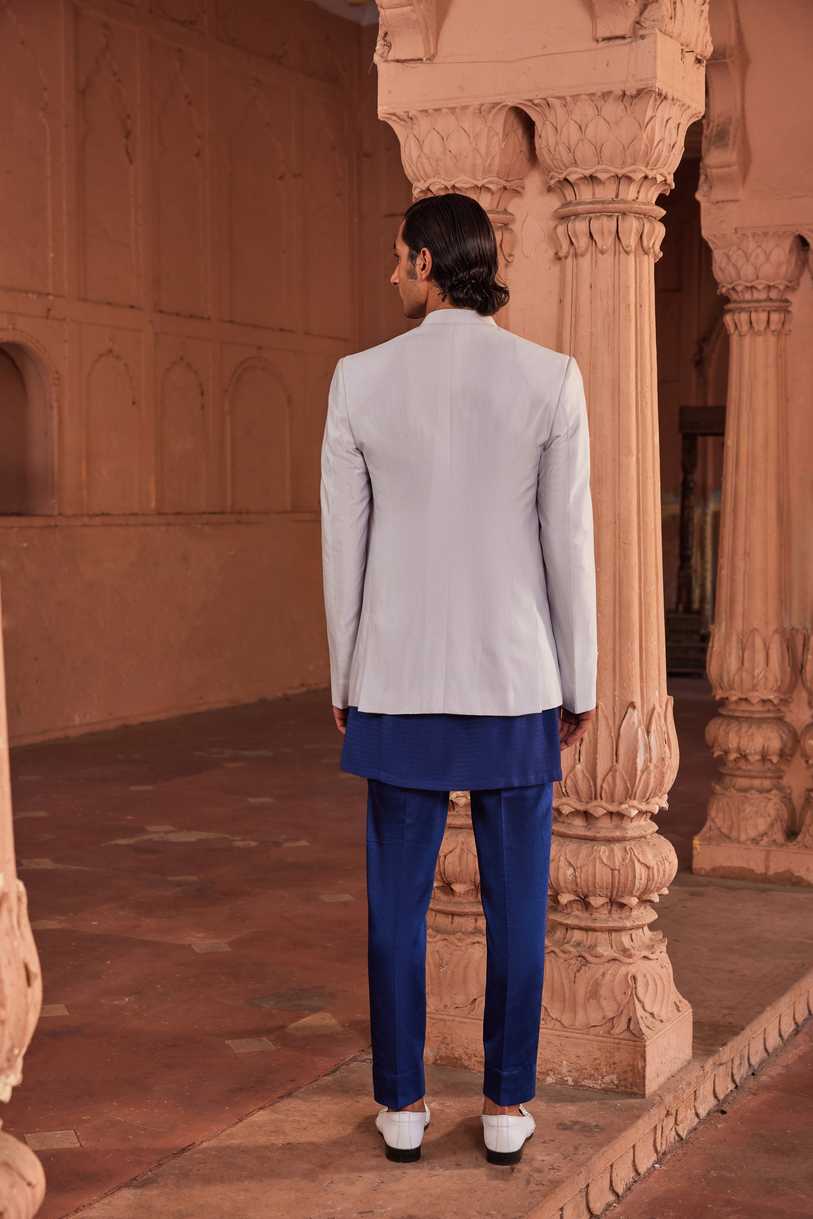 Full view of a jacket set showcasing exclusive hand-painted floral motifs, adorned with dabka and cutdana work, paired with a contrasting kurta and tailored pants for an elegant and artistic look.