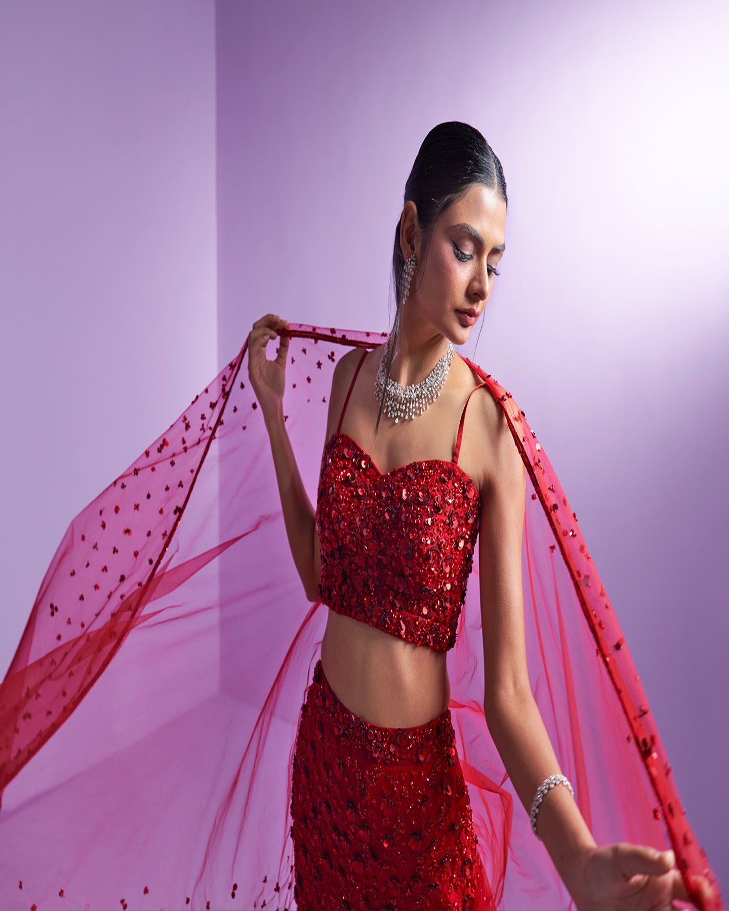 Drenched in passion, this vibrant red lehenga speaks volumes of timeless grace and fiery elegance. A symphony of tradition and modern allure, capturing hearts with every twirl. 