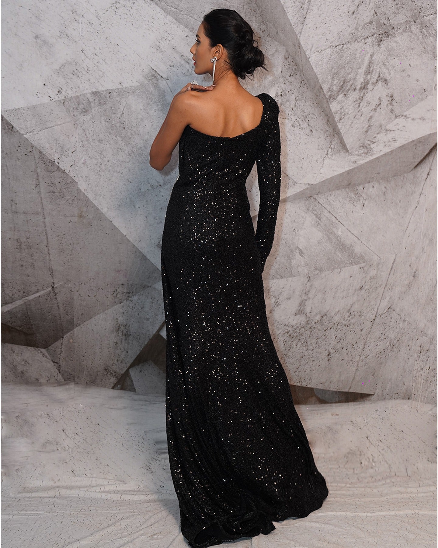 Draped in the midnight elegance of black, this gown speaks volumes with its glittering sequins and a touch of 3D feathers.