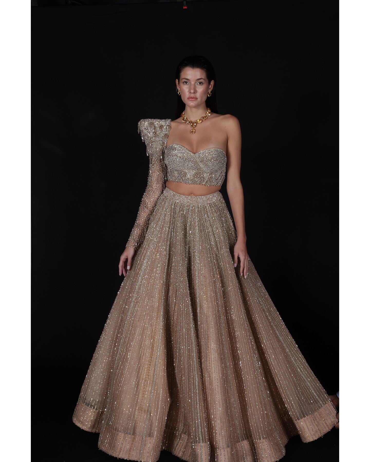 Elevate your elegance in our Champagne Lehenga, a sparkling symphony of stones, crystals, sequins, and Japanese cut-dana.