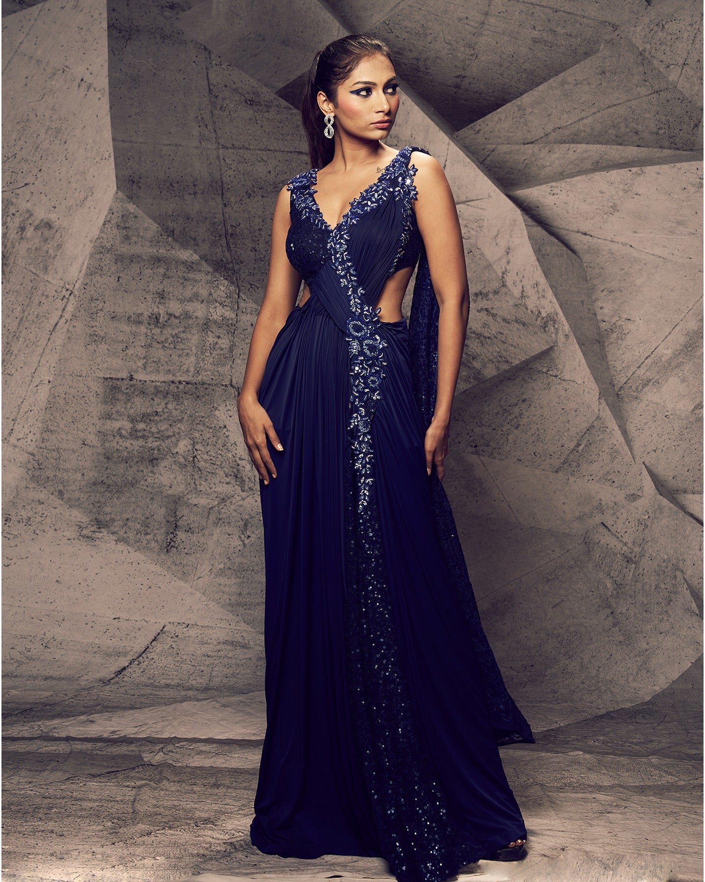Draped in the rich hues of blue, this gown is a masterpiece of glamour and sophistication. 