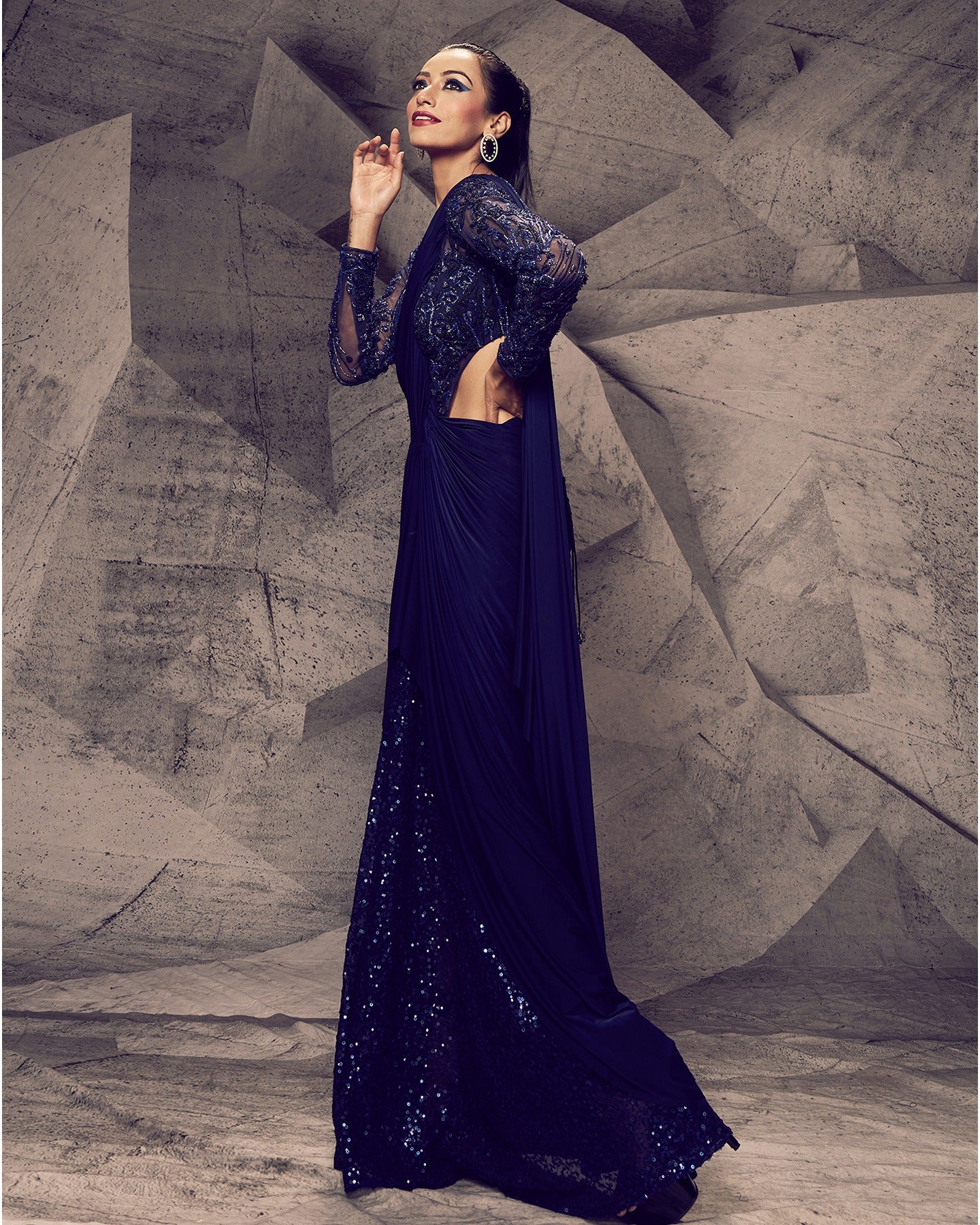 Draped in the enchanting hues of blue, this saree with a flowing lycra drape and sequin-embroidered pleats is a symphony of grace and sophistication, ready to make a statement.