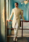 Step into elegance with our Sherwani Set, tailored from raw silk Sherwani, linen satin Kurta, and Pant in a chic pale olive shade. Customizable to reflect your style, it's the epitome of sophistication for weddings and cultural events. 