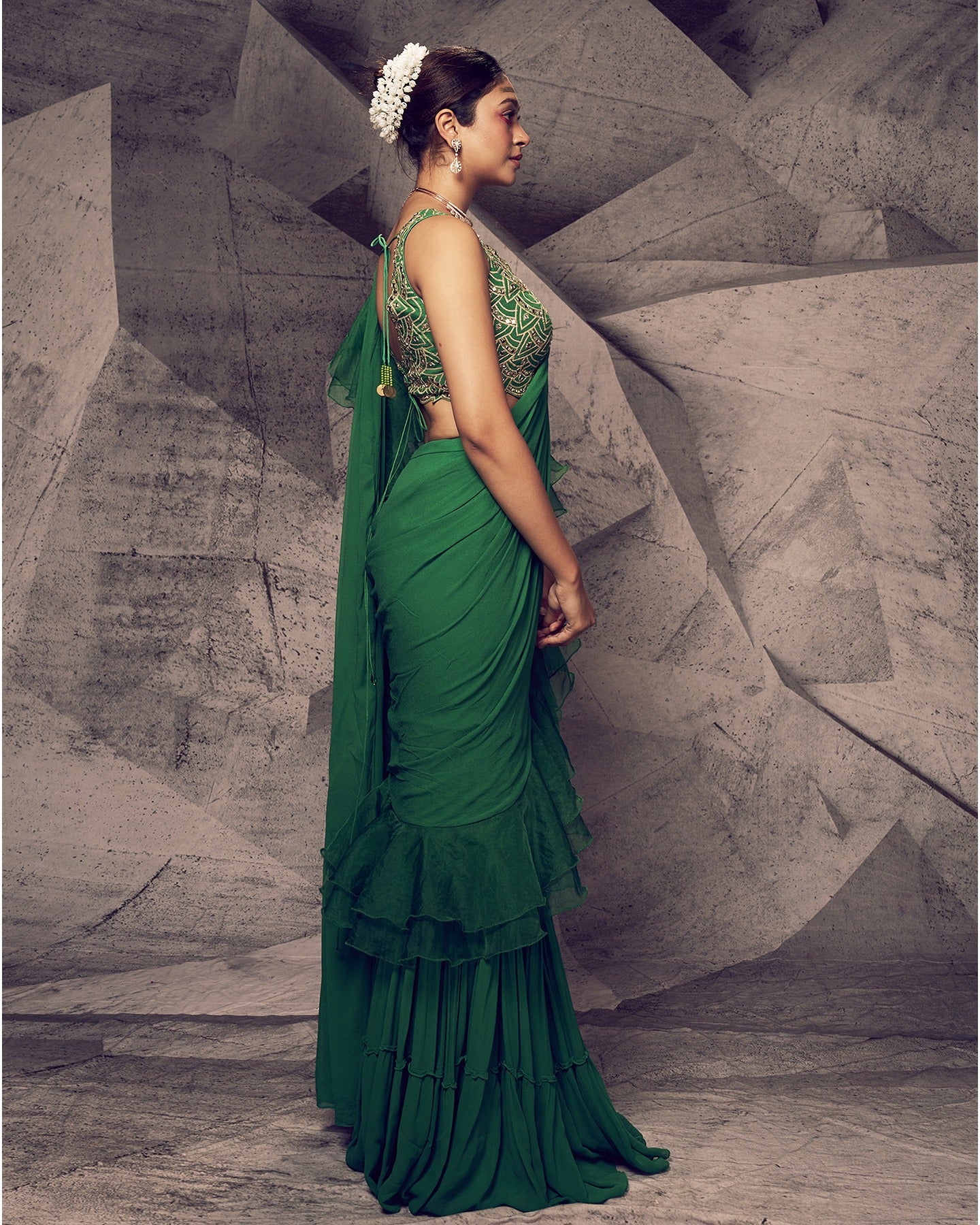 Draped in the festive hues of green, this saree is a symphony of elegance and contemporary flair. 