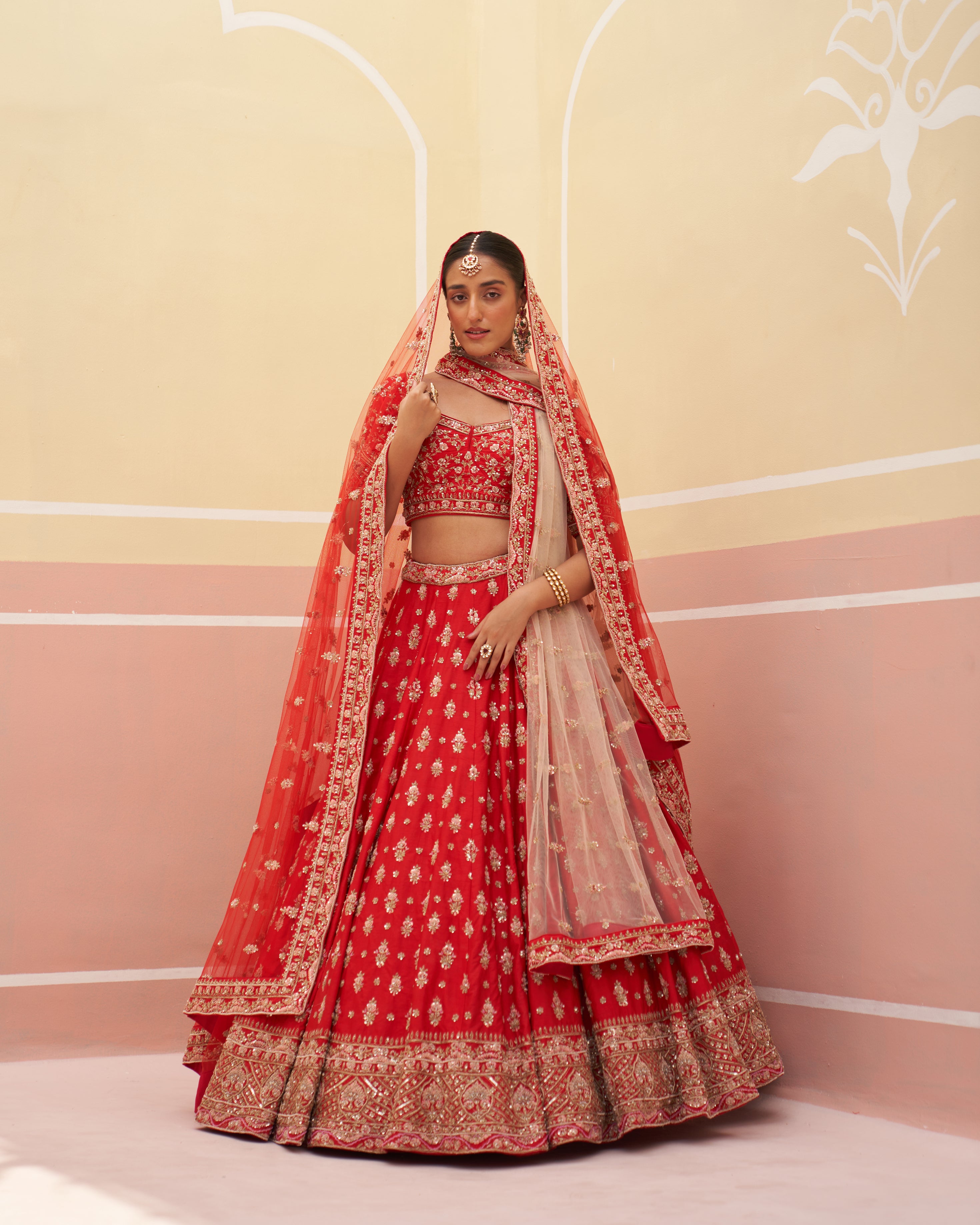 Elegant red raw silk bridal lehenga with intricate embroidery