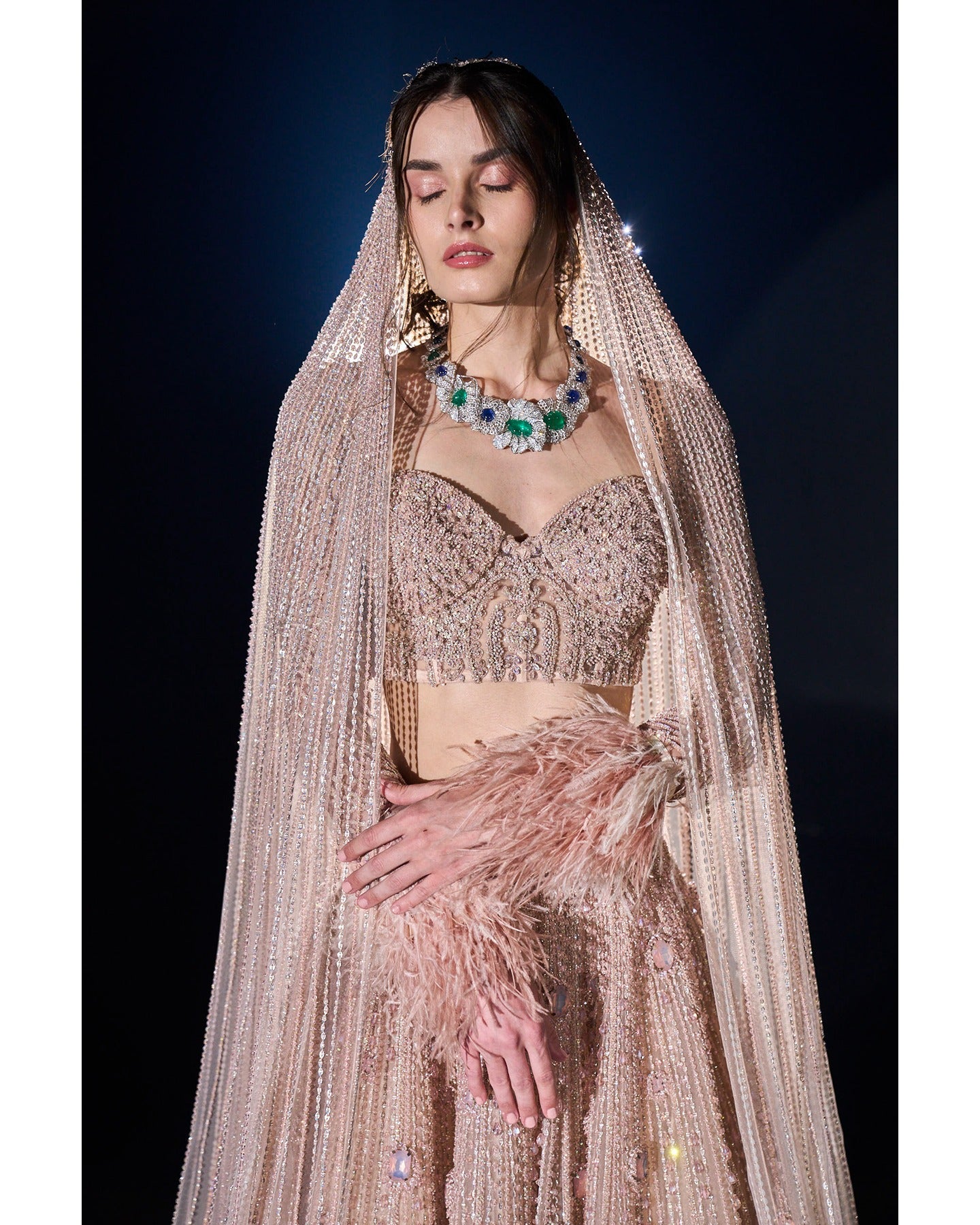 Draped in elegance, our Nude Pink Lehenga intricately embellished with stones, crystals, sequins, and Japanese cut-dana, unveils a timeless symphony of grace and sophistication.
