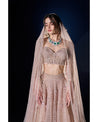Draped in elegance, our Nude Pink Lehenga intricately embellished with stones, crystals, sequins, and Japanese cut-dana, unveils a timeless symphony of grace and sophistication.