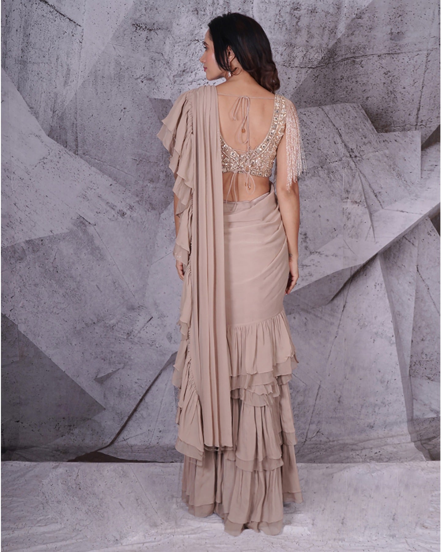 Draped in the subtle elegance of beige, this saree weaves a tale of timeless grace. A canvas of sophistication that speaks volumes in every fold. 