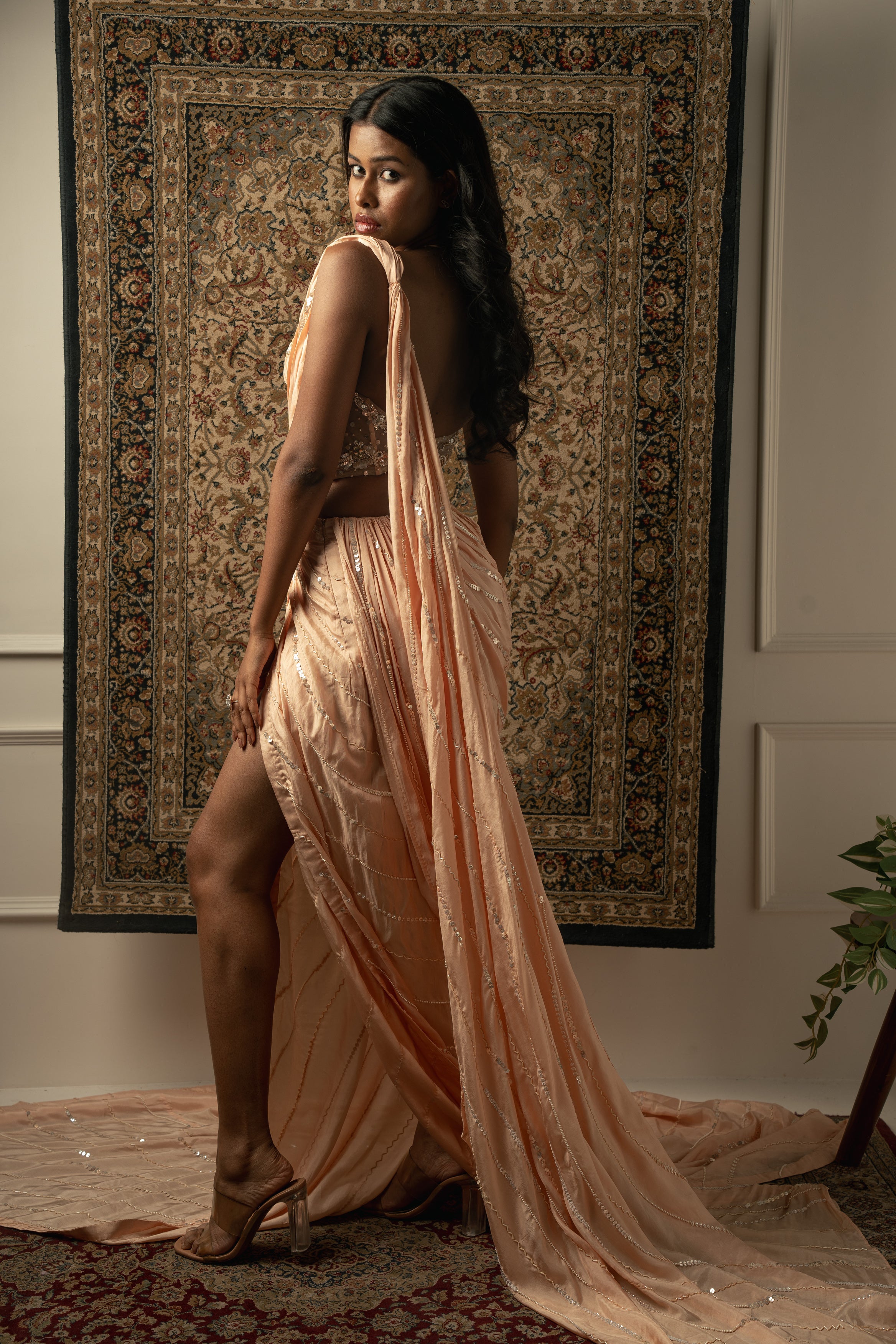 Draped in elegance: Peach satin silk saree paired with a chic net blouse. Perfect for those special occasions.