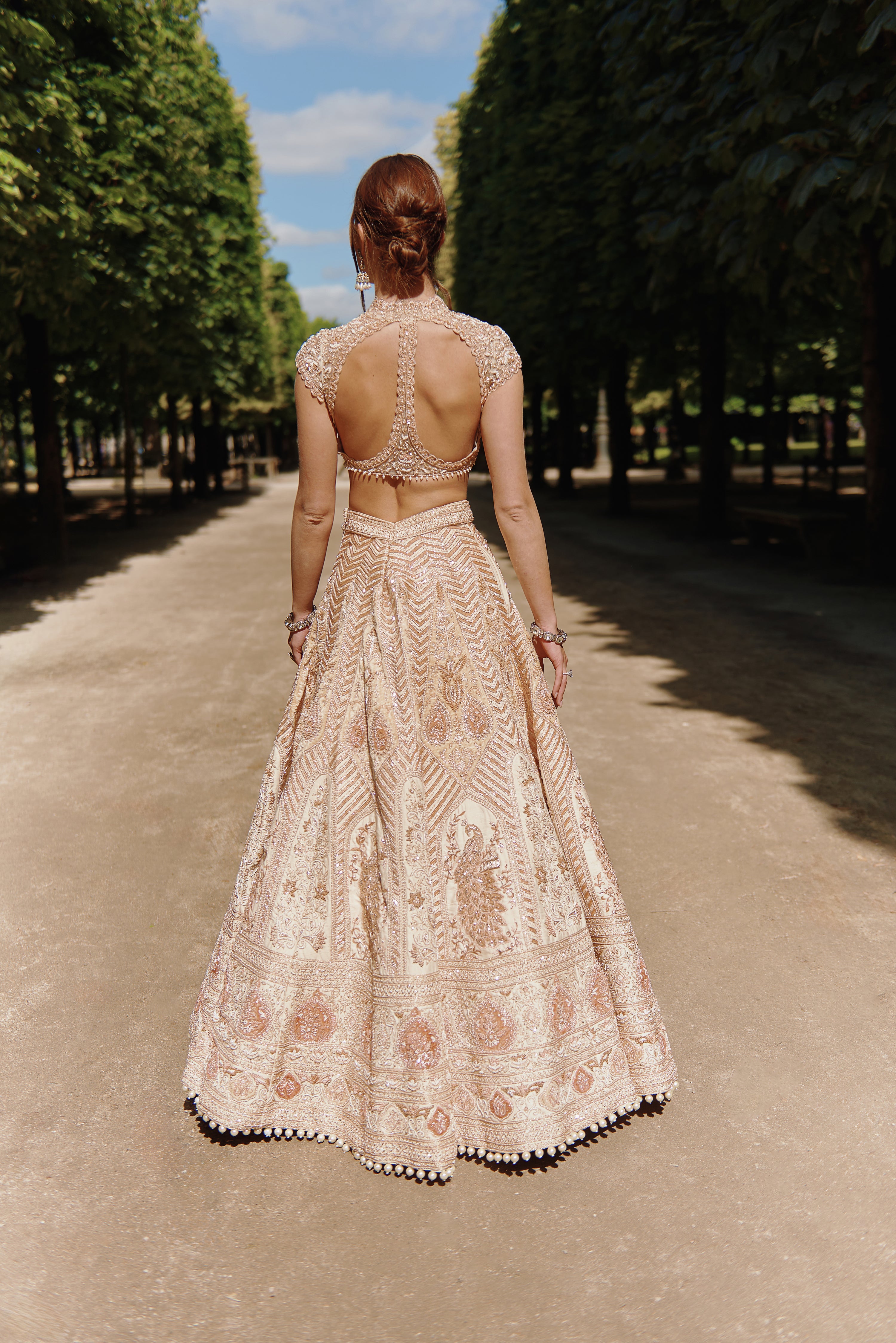 Rust and beige lehenga set with detailed handcrafted embroidery on raw silk and velvet, paired with a net blouse and a shimmering silk dupatta, offering a refined and elegant look