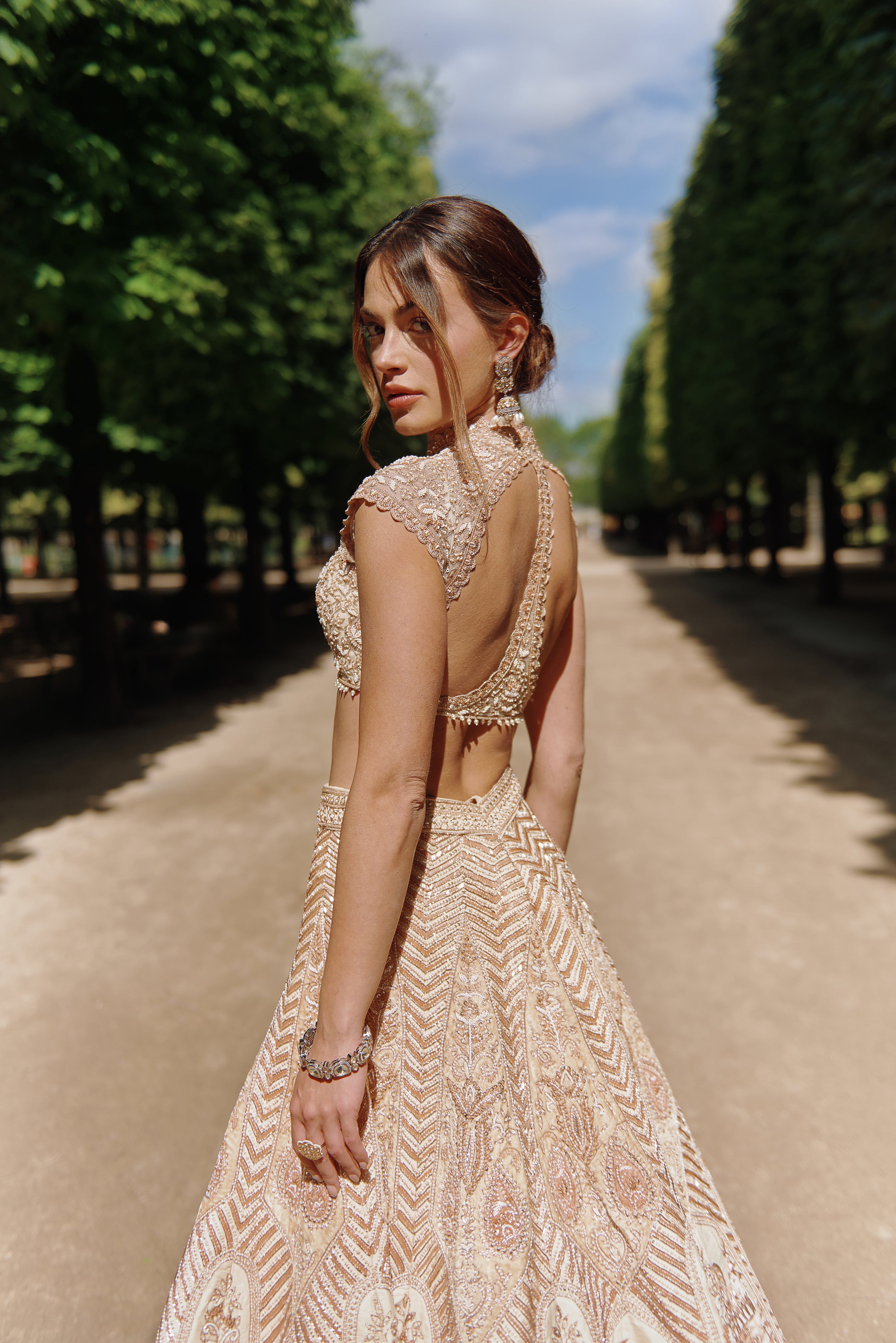 Elegant rust and beige lehenga set, adorned with delicate hand embroidery. The luxurious raw silk and velvet lehenga is complemented by a net blouse and a shimmering silk dupatta.