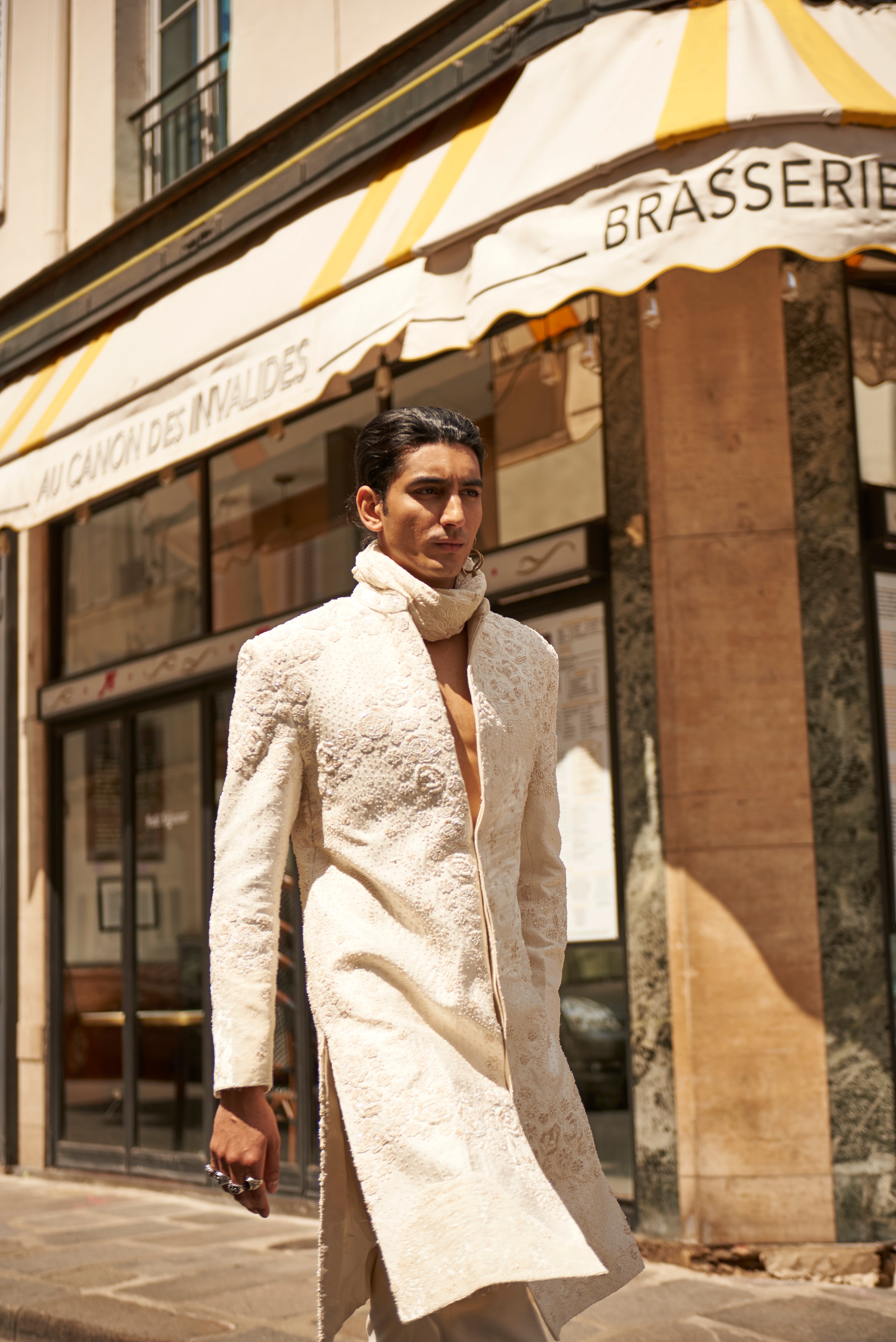 White raw silk and velvet sherwani set with hand-embroidered details and monochromatic velvet patchwork. Paired with a Chanderi silk kurta, pant, and a linen satin dupatta, offering a sophisticated and elegant appearance.