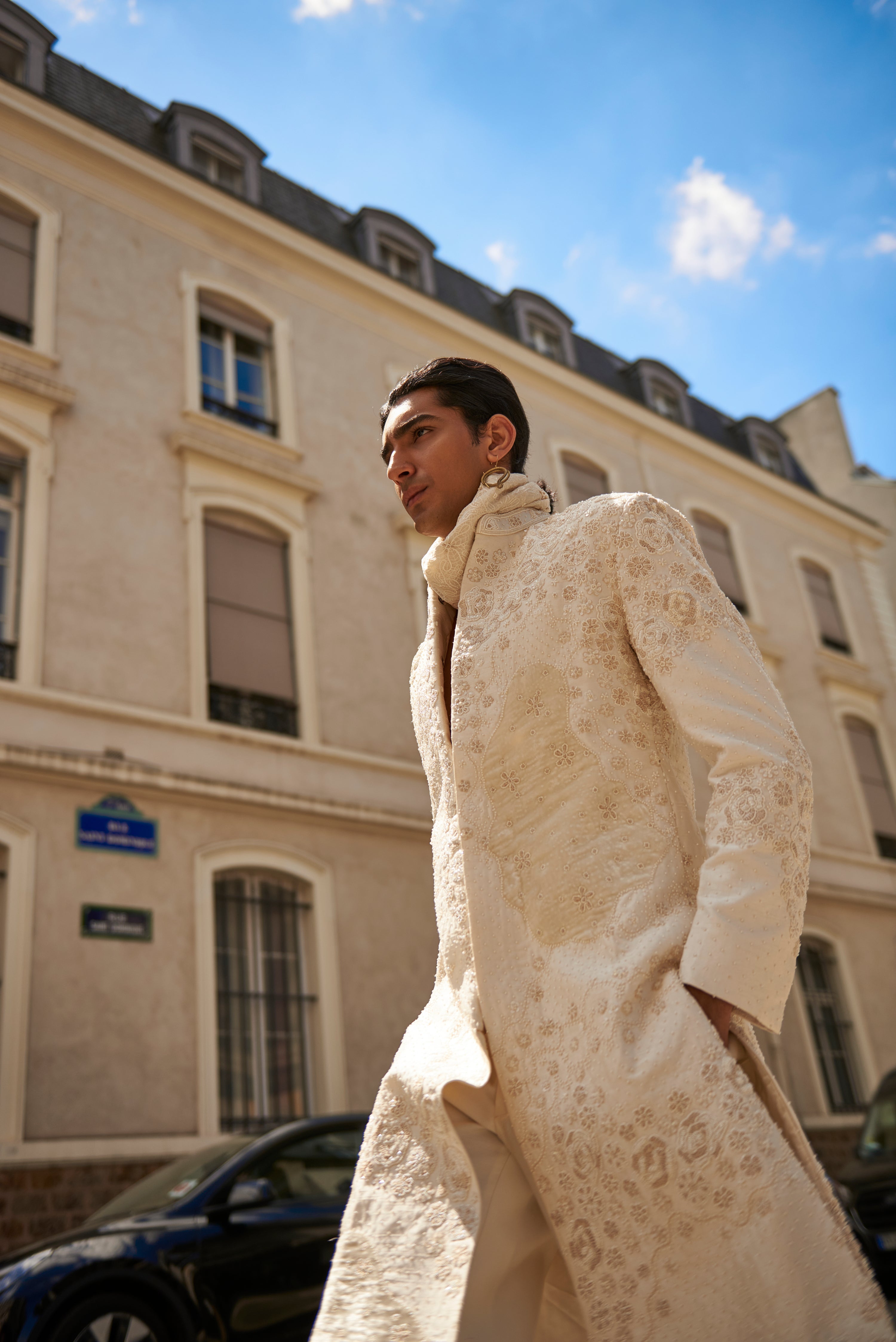 Elegant white sherwani set featuring detailed embroidery and velvet patchwork on raw silk. The ensemble includes a Chanderi silk kurta, pant, and a luxurious linen satin dupatta for a refined look