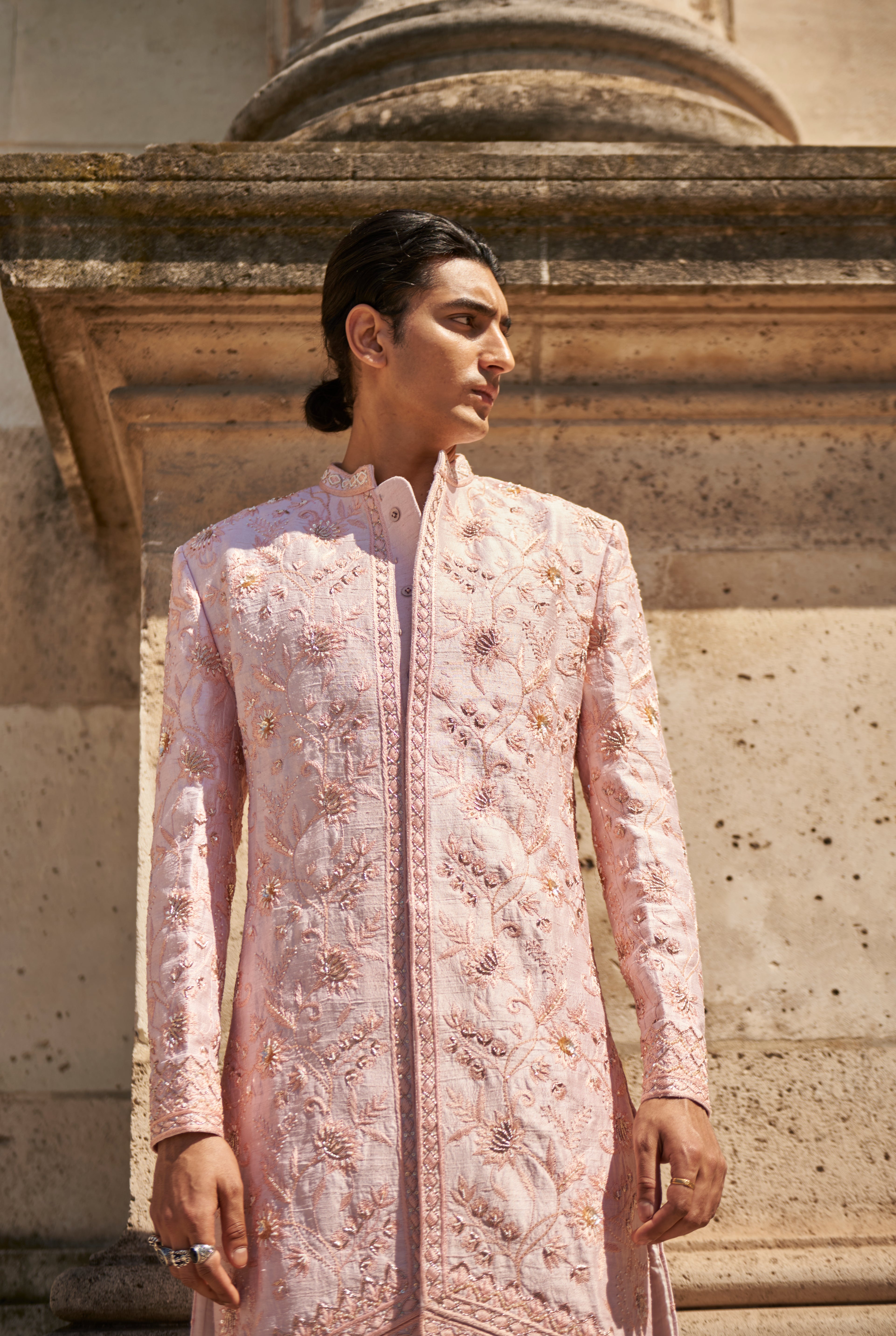 Blush pink sherwani set with intricate hand embroidery, crafted from luxurious raw silk. Paired with a Chanderi silk kurta, pant, and matching dupatta, this ensemble exudes sophistication and timeless elegance