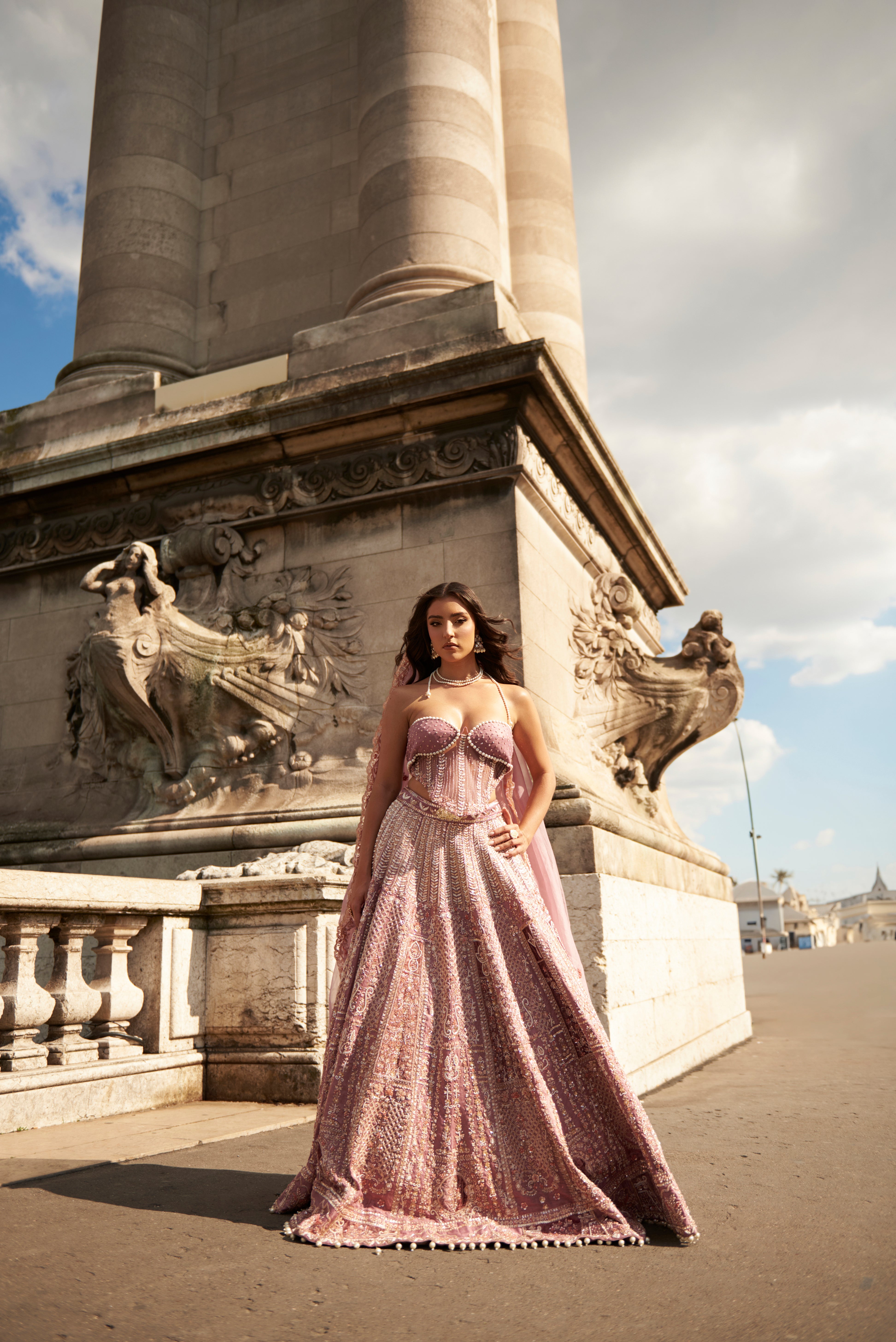 Lilac lehenga set with intricate handwork embroidery and delicate pearl details on luxurious raw silk. The ensemble features a net and raw silk blouse with a corset and off-shoulder design, complemented by a matching net dupatta