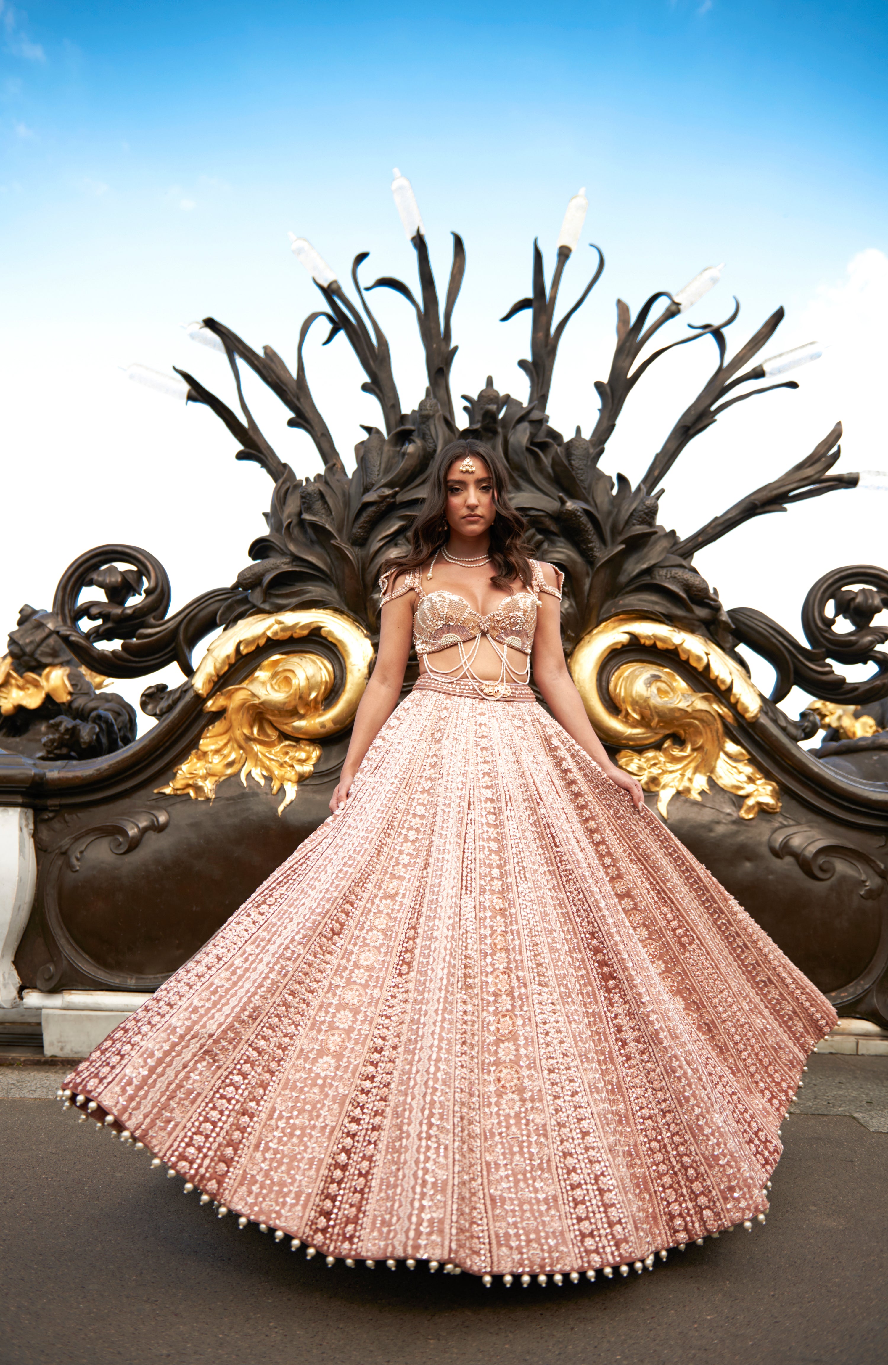 Brown lehenga set in caramel shade, featuring hand embroidery, pearl accents, and pearl danglers. The linen silk lehenga and sea shell silhouette blouse, paired with a net dupatta, offer a timeless and ethereal look.