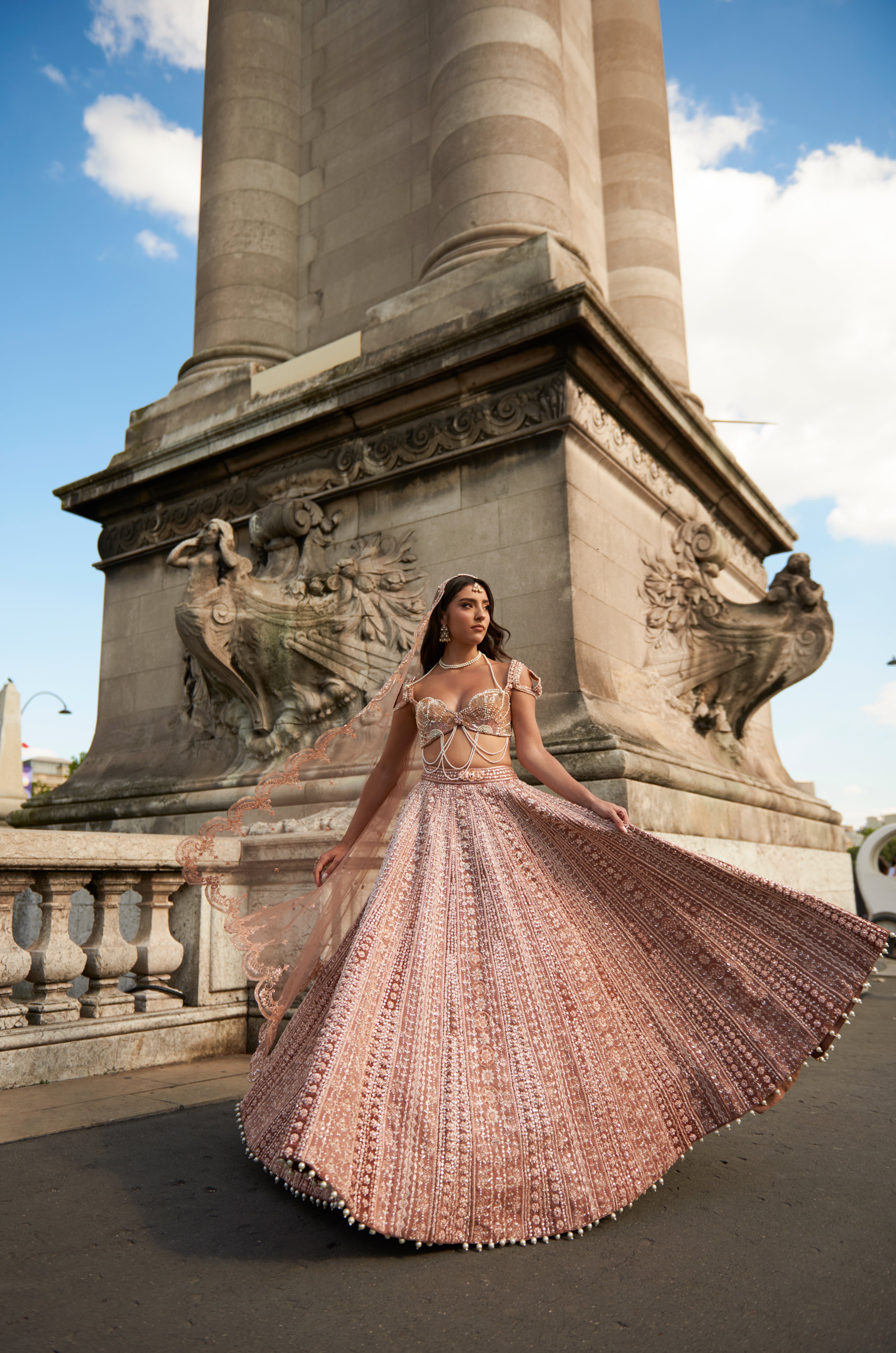 Caramel brown lehenga set with intricate hand embroidery, pearl details, and elegant pearl danglers. The linen silk lehenga is paired with a net and linen silk blouse inspired by a sea shell silhouette, complemented by a delicate net dupatta