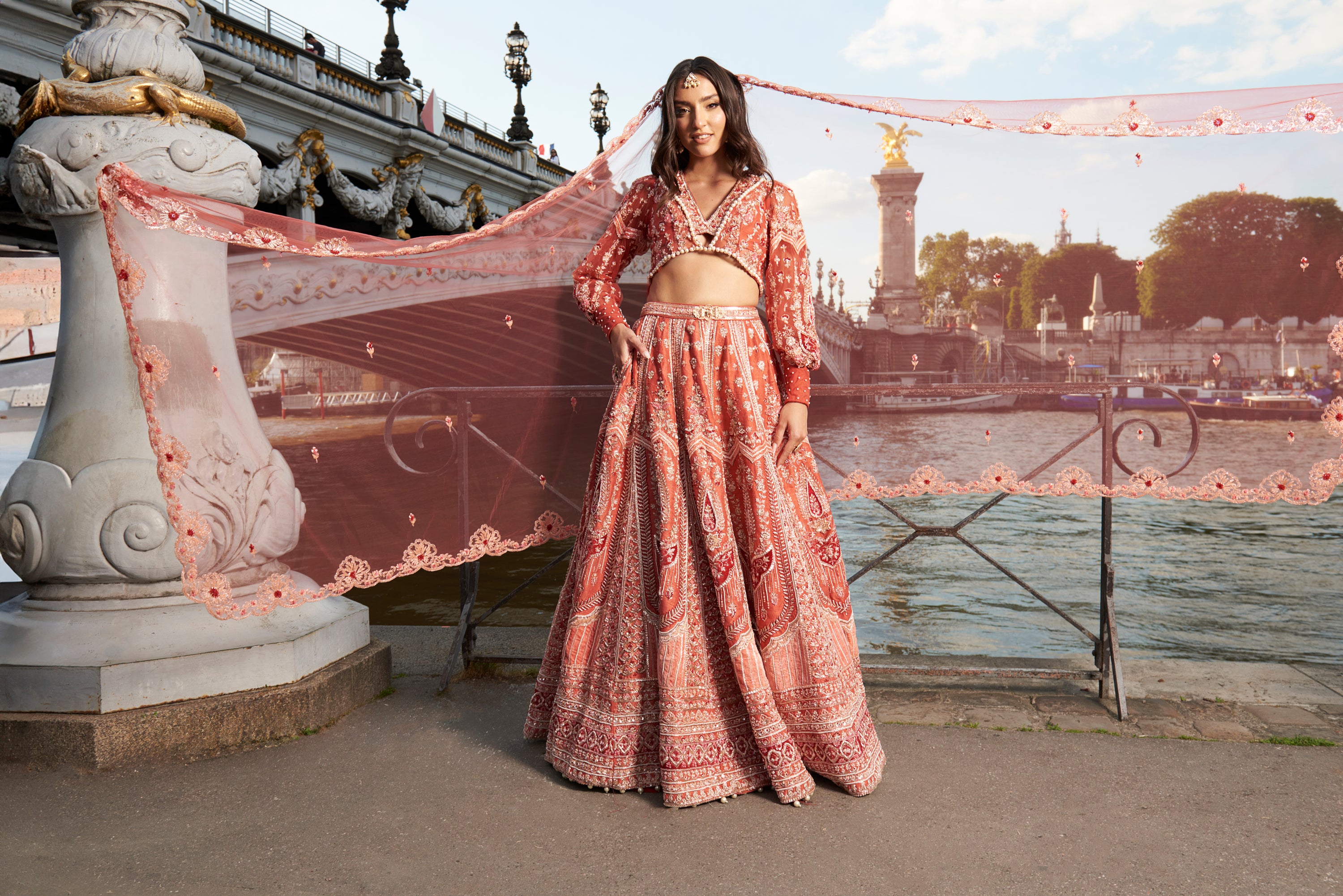 Vibrant red lehenga set featuring intricate hand embroidery on raw silk and velvet, paired with a net blouse in an Indian 'Koti' silhouette and European-inspired puff sleeves