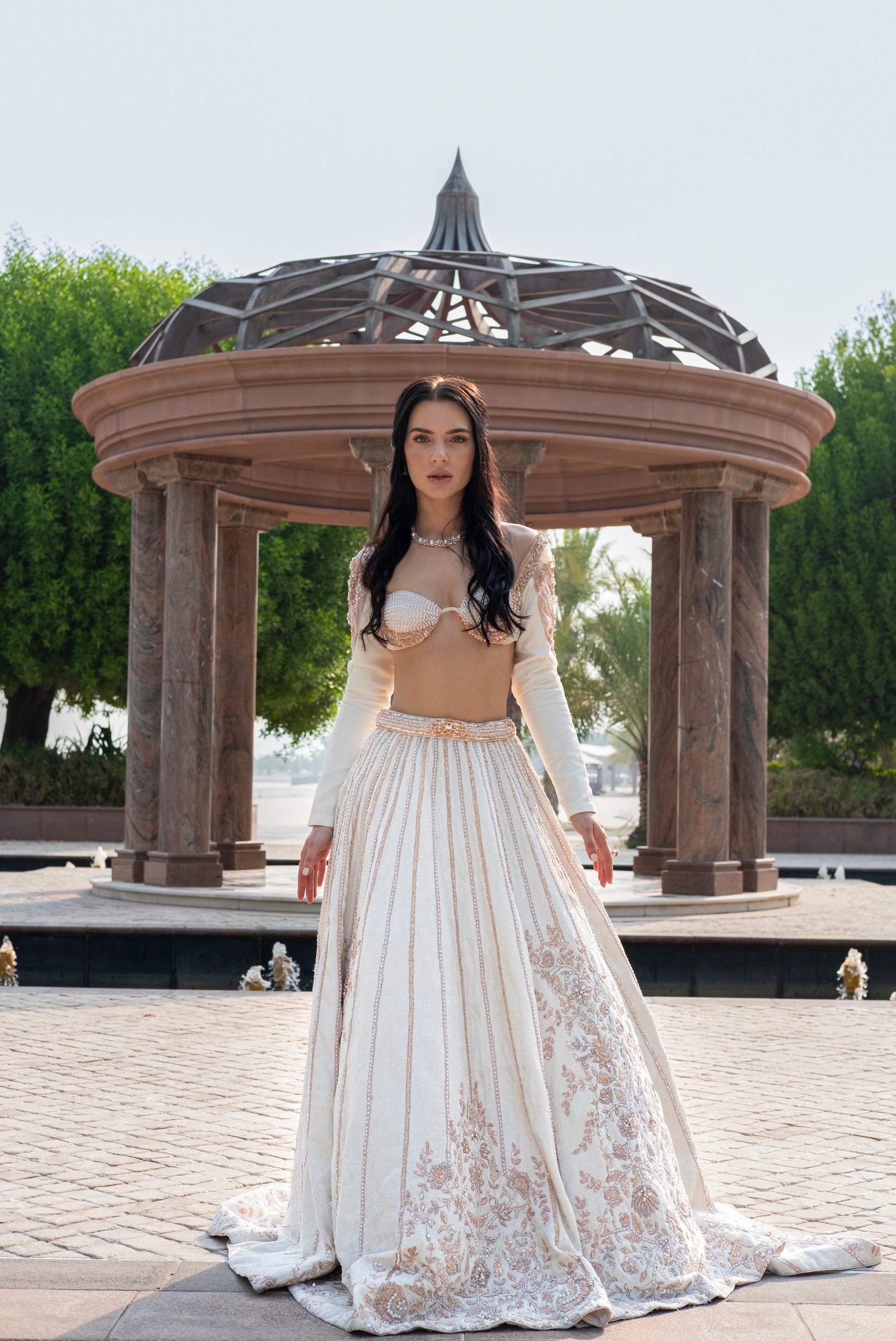 Pearl white linen satin lehenga with intricate Chikankari work, full-sleeved blouse adorned with pearls, and a light net dupatta