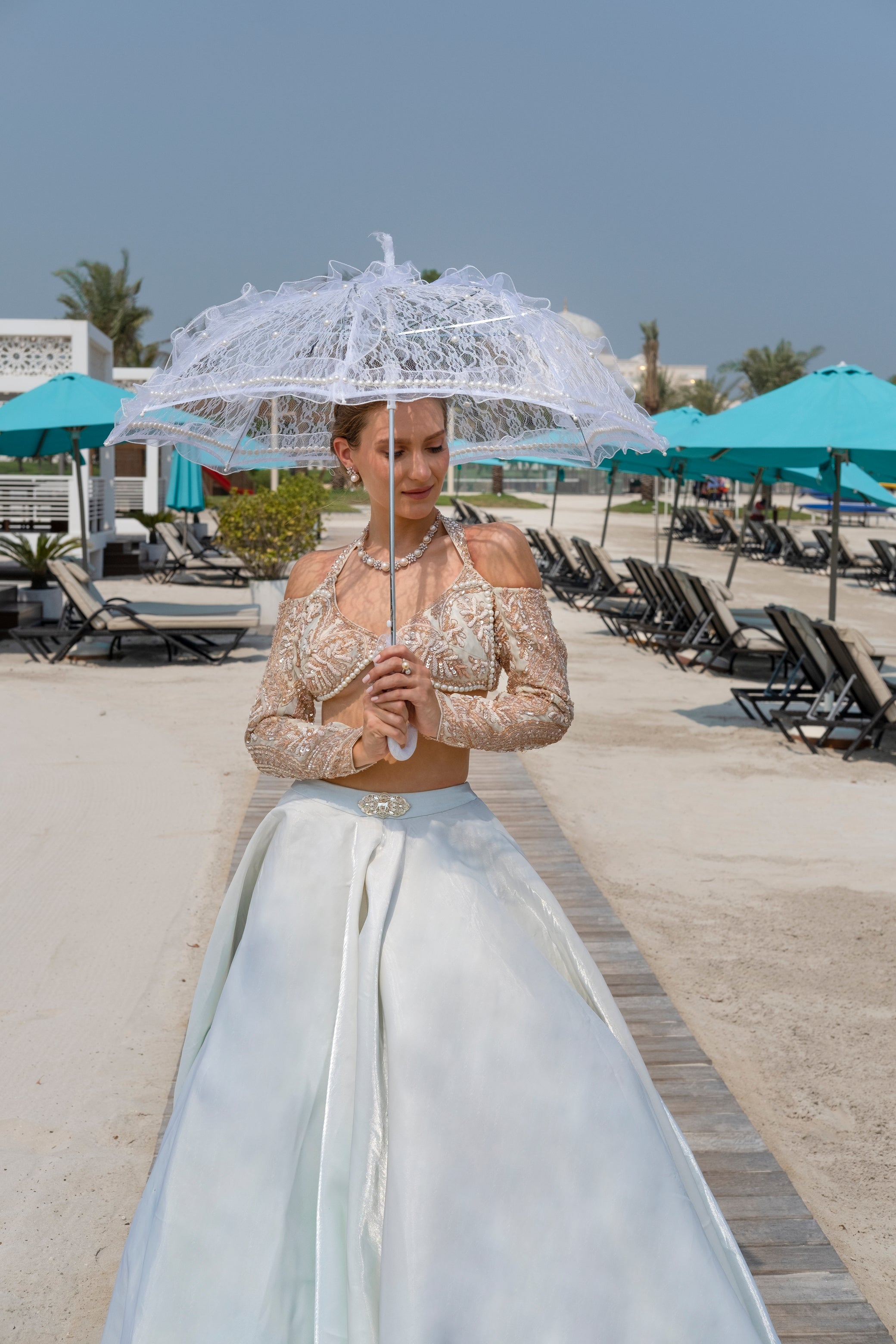 Chic glass organza lehenga in mint, complemented by a full-sleeved blouse with intricate handwork and a graceful net dupatta