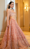 Peach velvet lehenga with Zari, Nakshi, and Resham handwork, puff-sleeved blouse with net detailing, and embroidered net dupatta